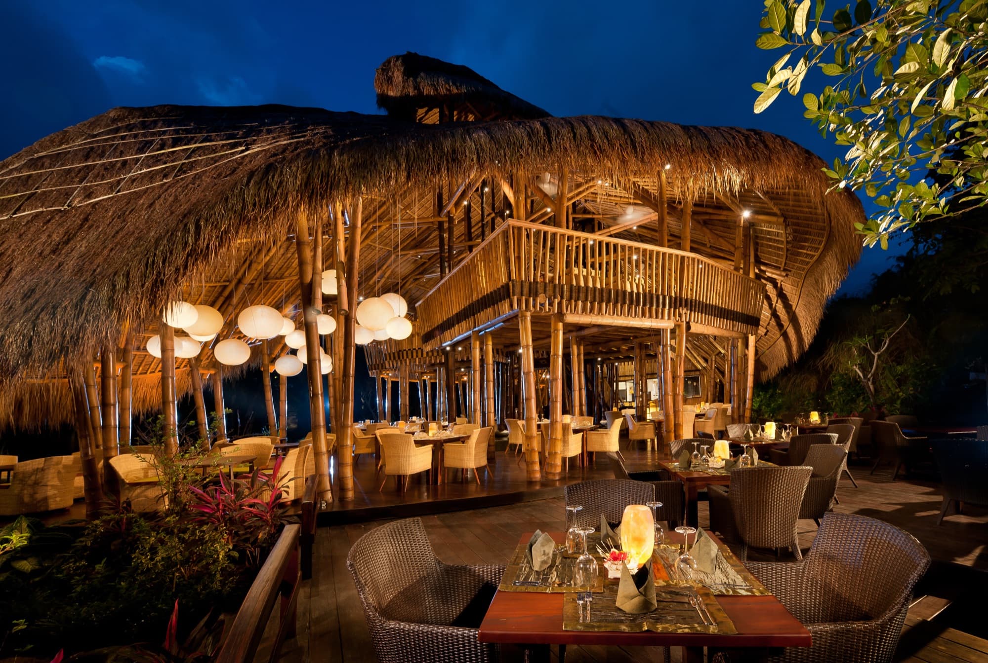 Restaurant interior at night with set tables and paper lanterns