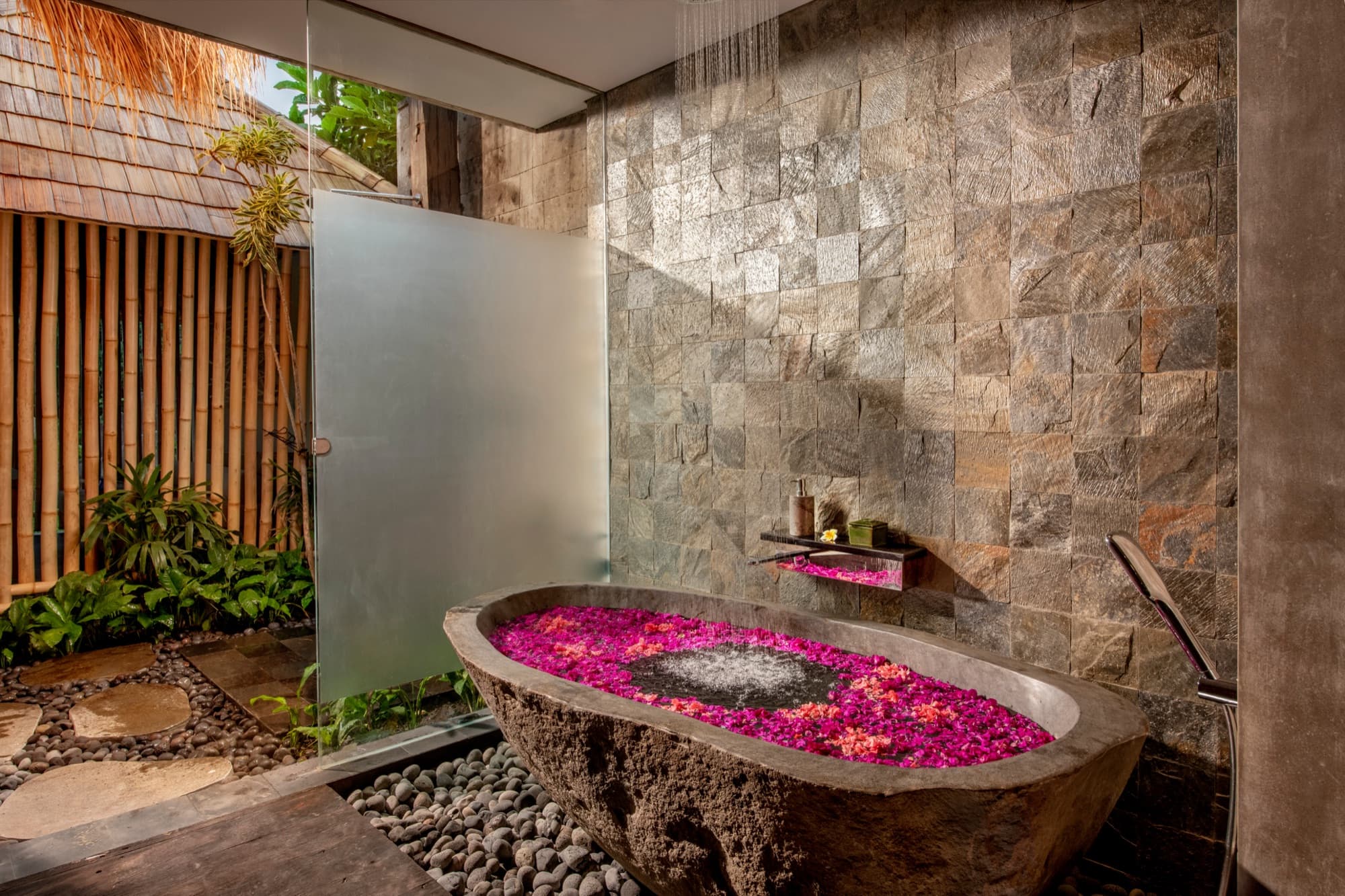 Stone bathtub filled with bougainvillea petals