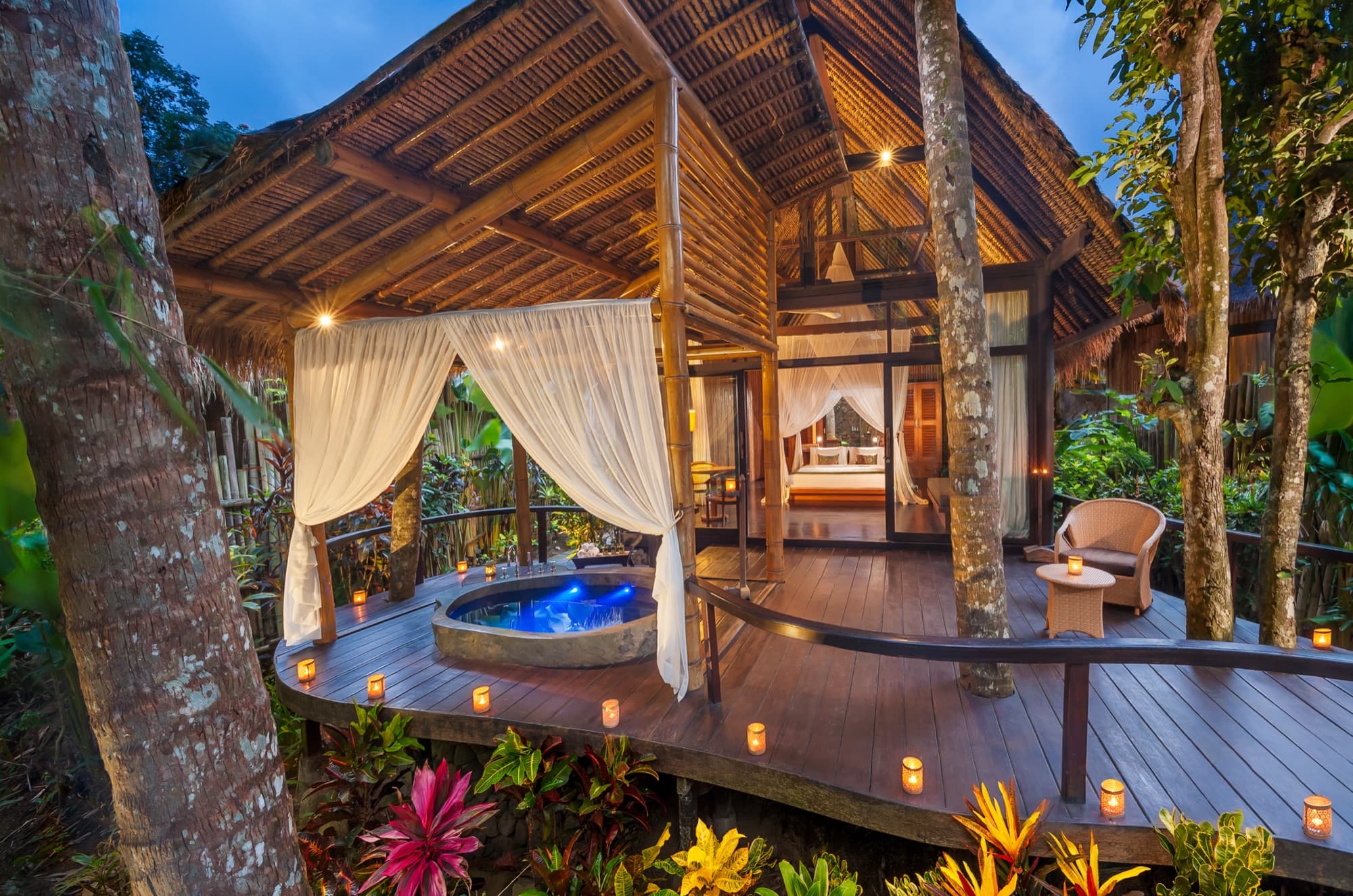 Suite exterior at dusk with hot tub and candle lanterns