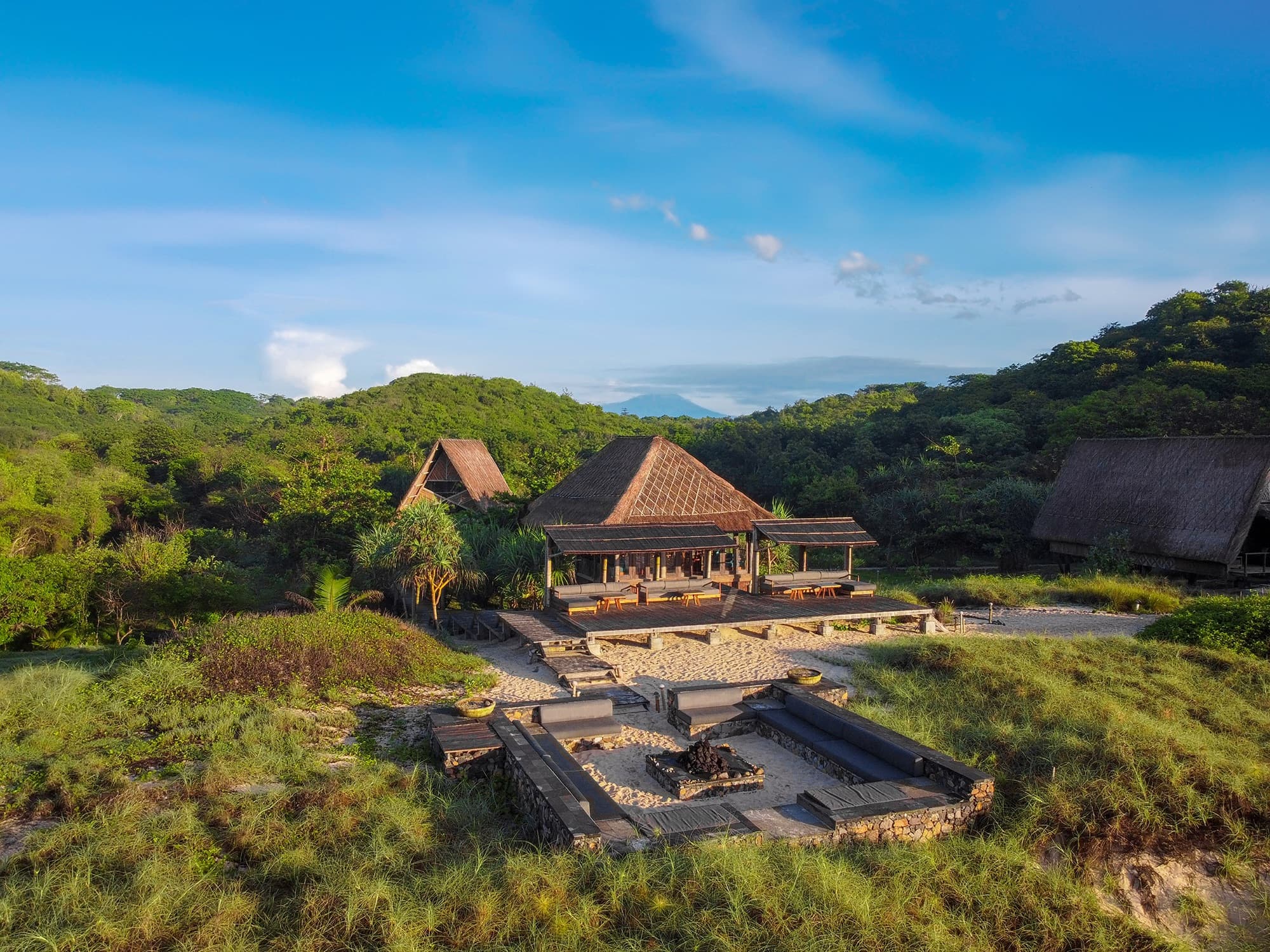 Aerial view of the Dermaga restaurant pavilion and fire pit area from above, surrounded by vegetation