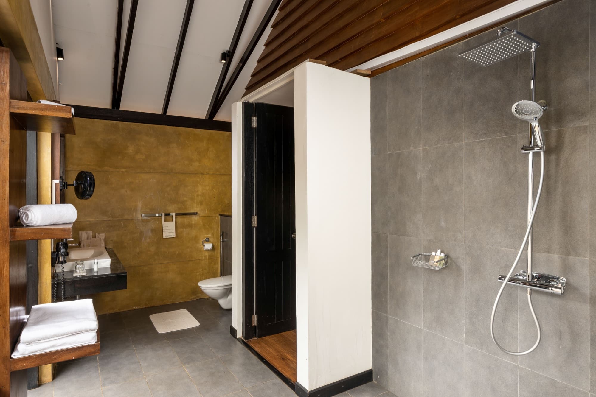 Wooden cabin bathroom with rainfall shower and concrete tiles
