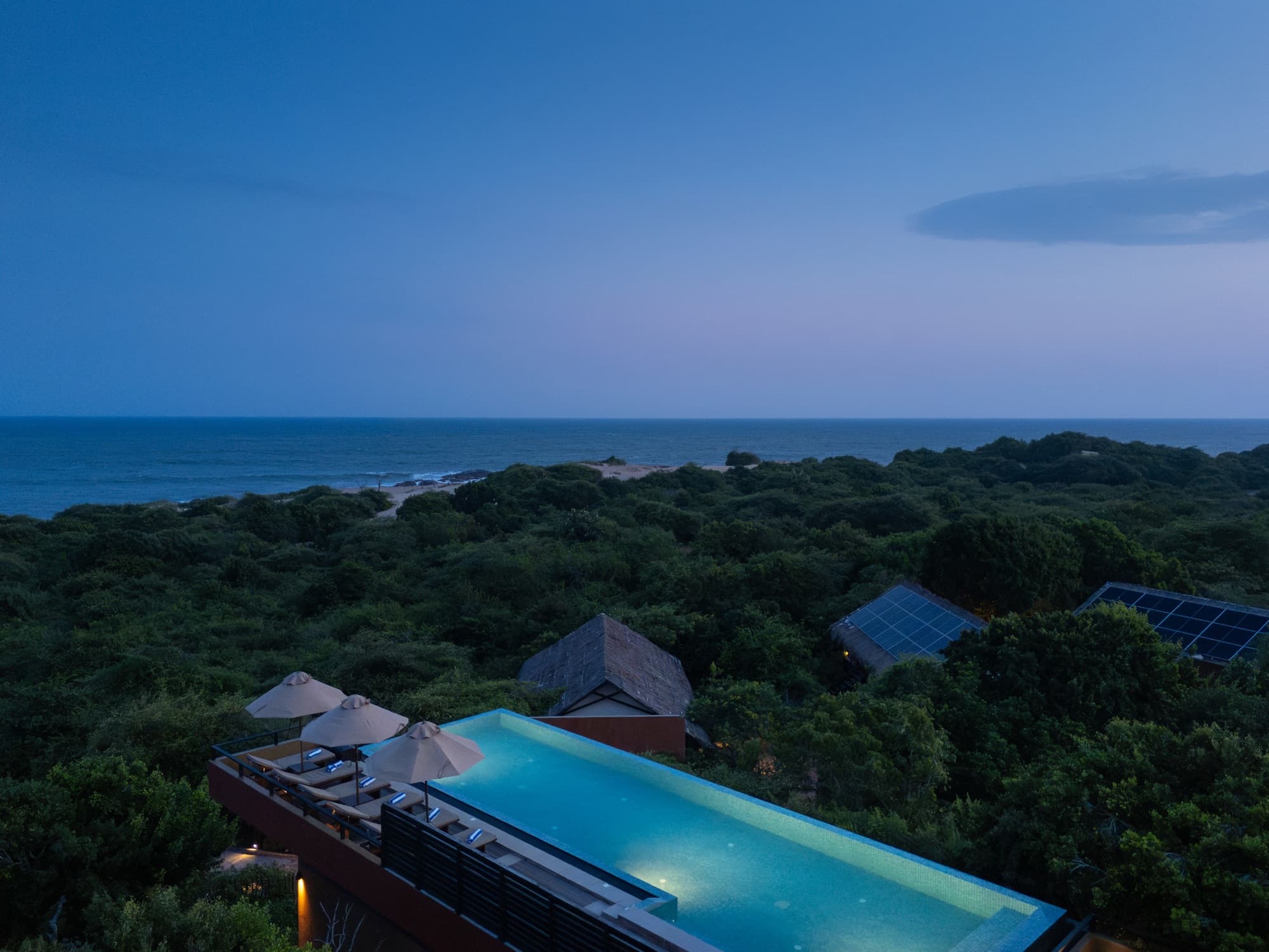 Rooftop infinity pool at dusk facing the Indian Ocean horizon
