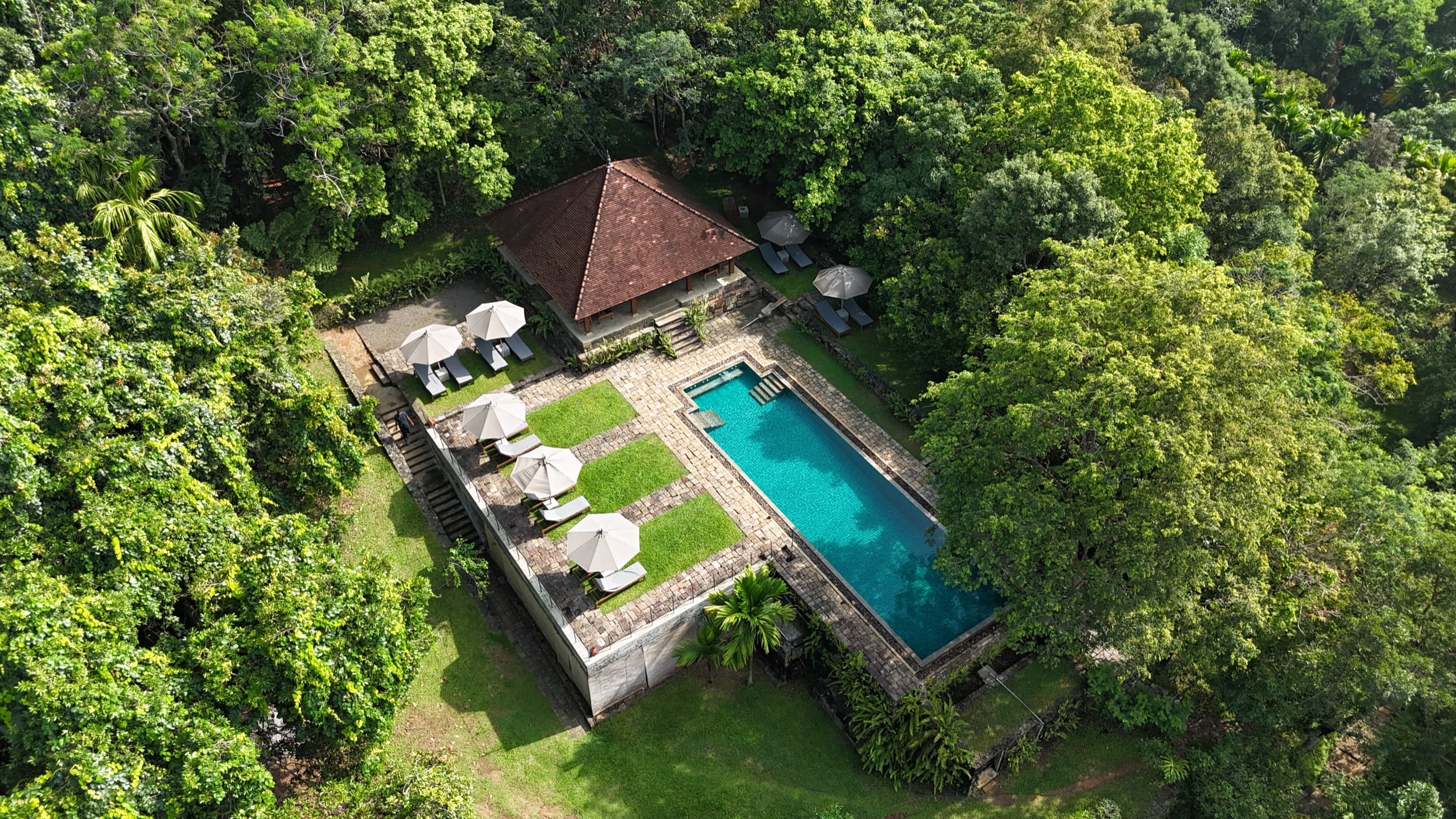 Aerial view of the pool, pavilion and sun-loungers in the forested estate — Living Heritage Koslanda, Uva highlands, Sri Lanka
