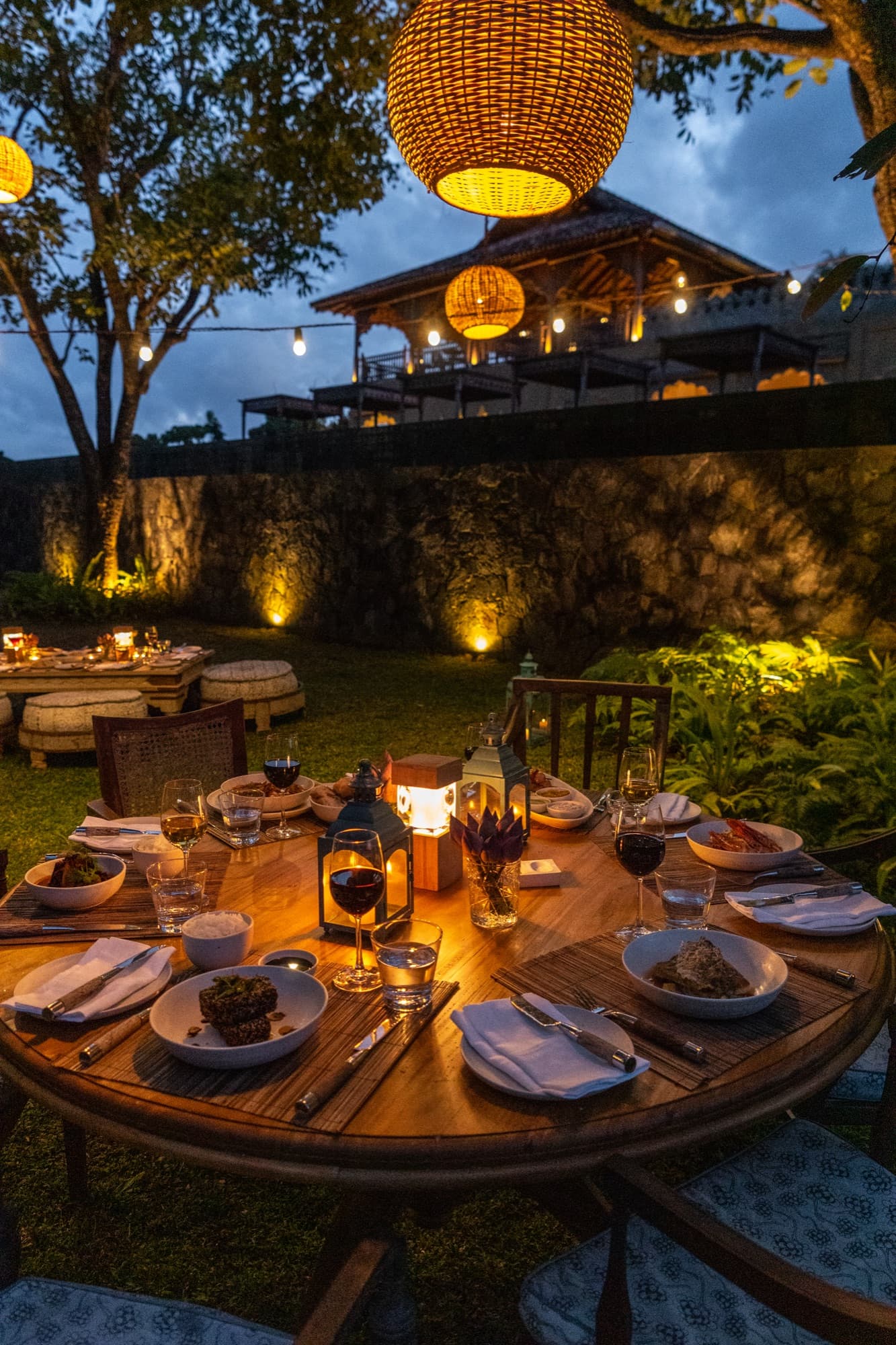 A table set with lanterns for an evening dinner in the garden
