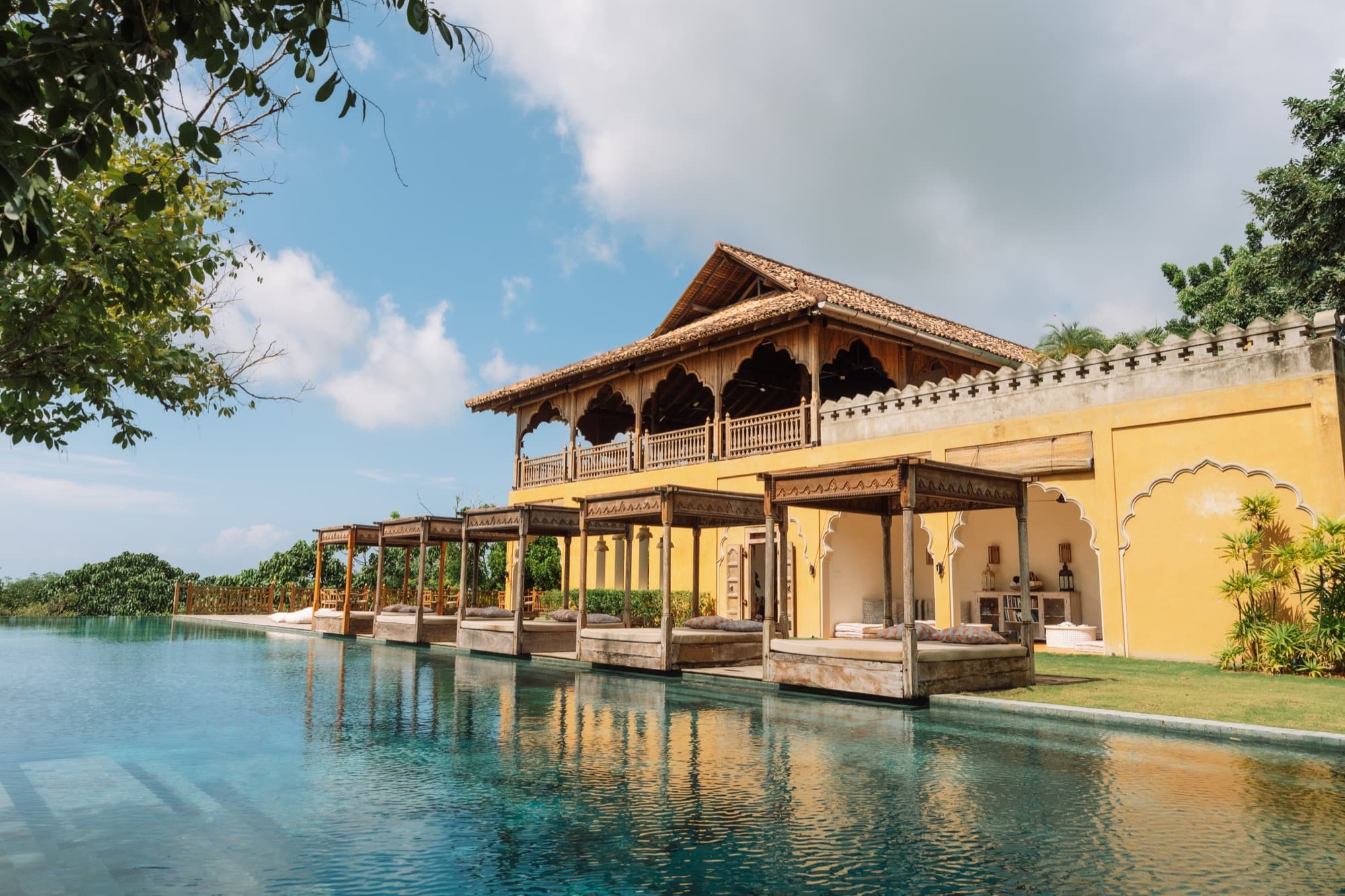 The ochre Moorish Main House reflected in the 35-metre salt-water infinity pool