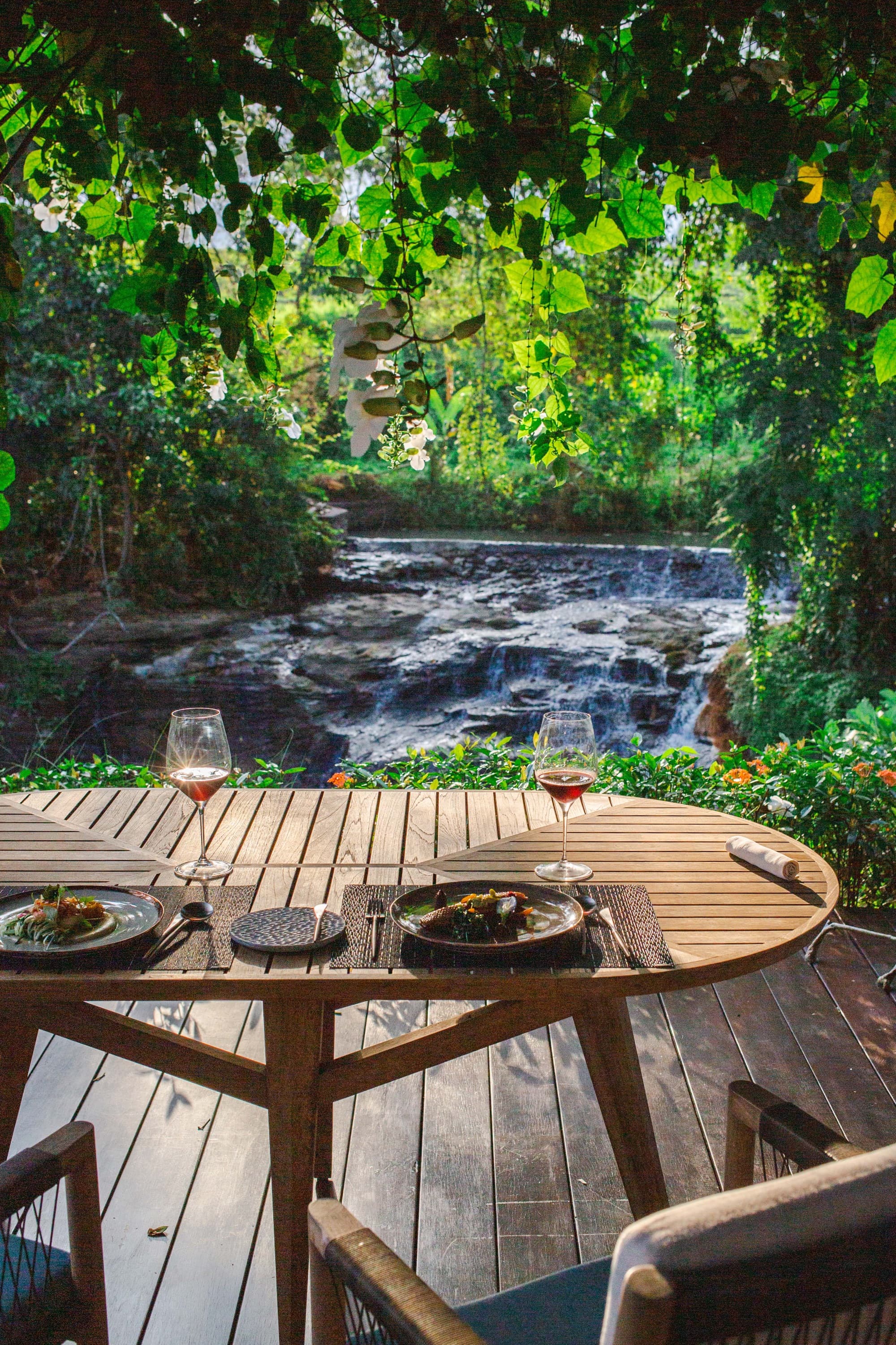 A table set for two beside the river and waterfall