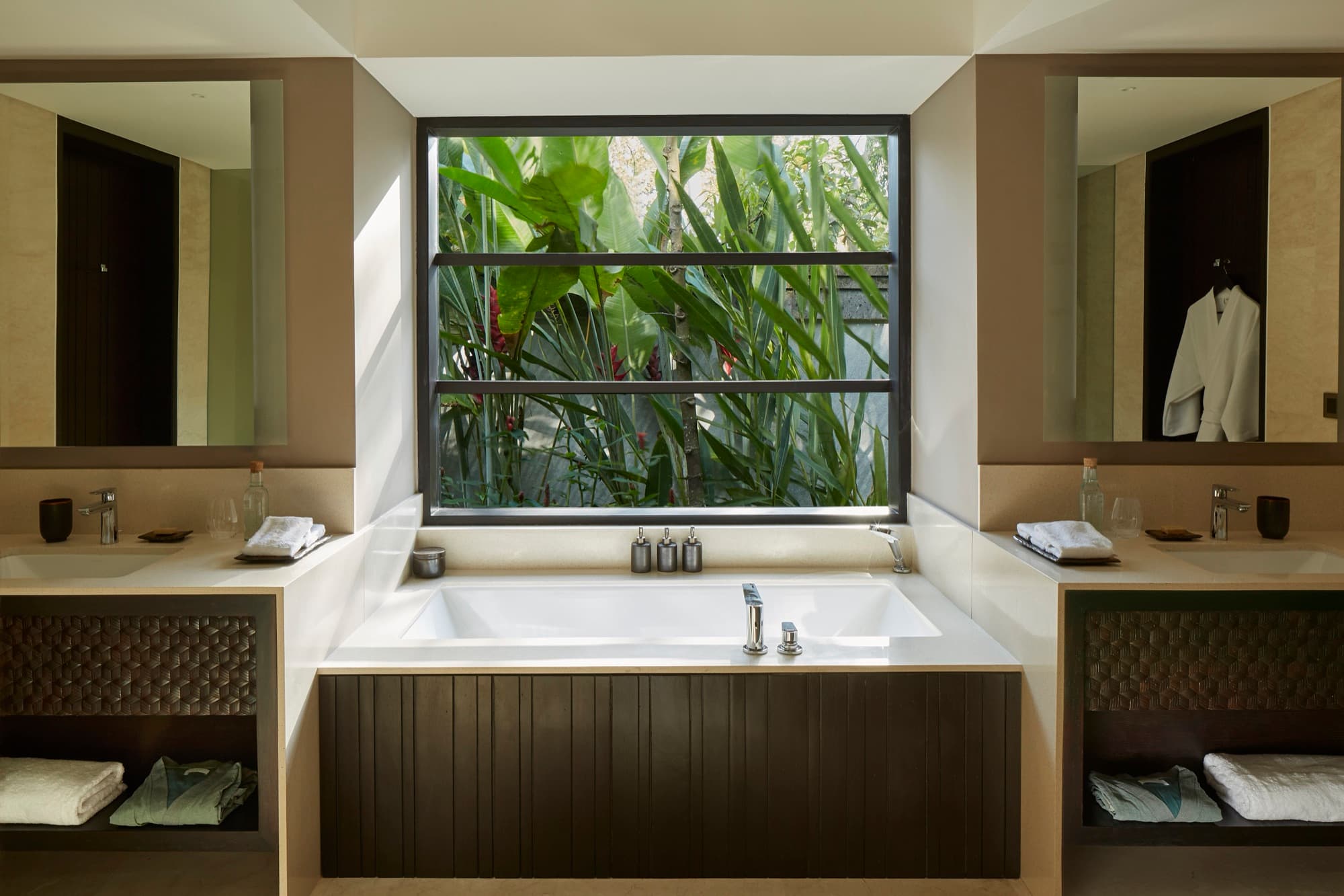Bathroom with soaking tub and a window onto the jungle at a Jungle Pool Pavilion