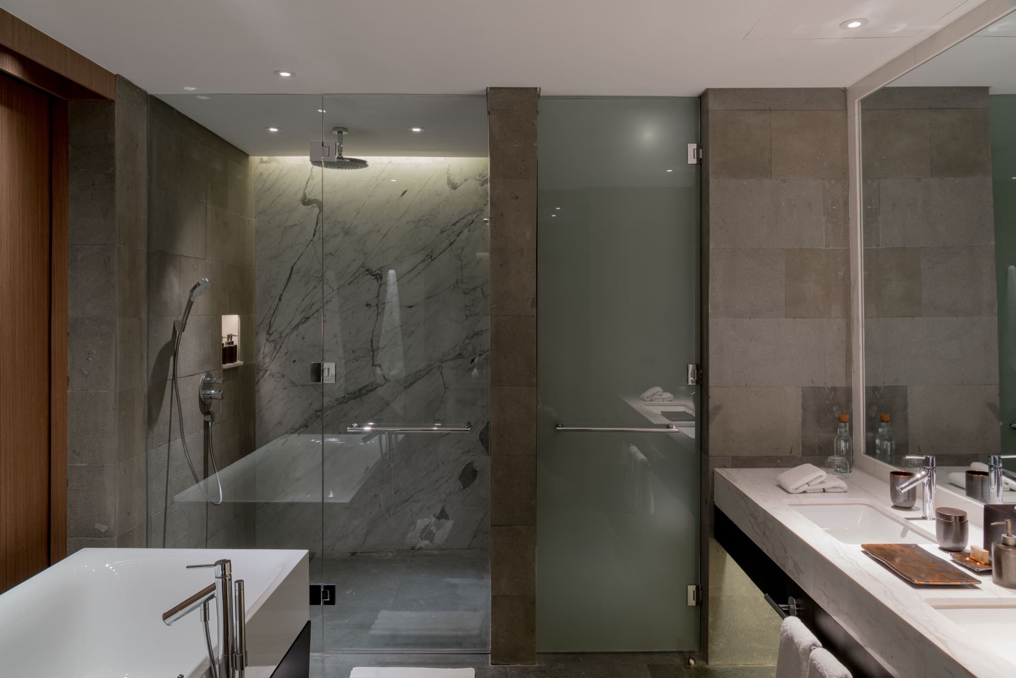 Residence bathroom with marble walk-in shower and freestanding tub
