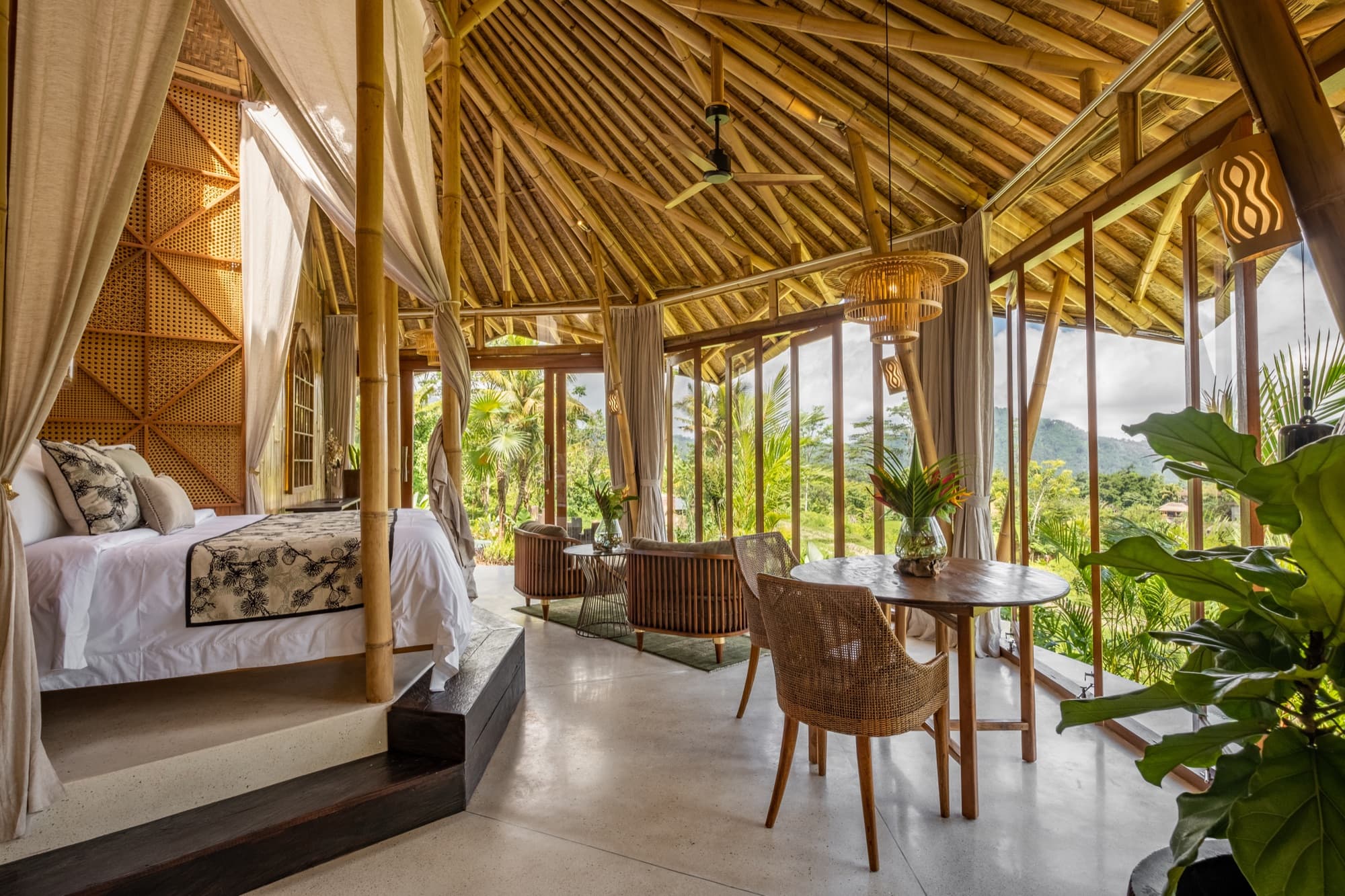 Samudra villa bedroom — bamboo architecture with canopy bed and panoramic valley views
