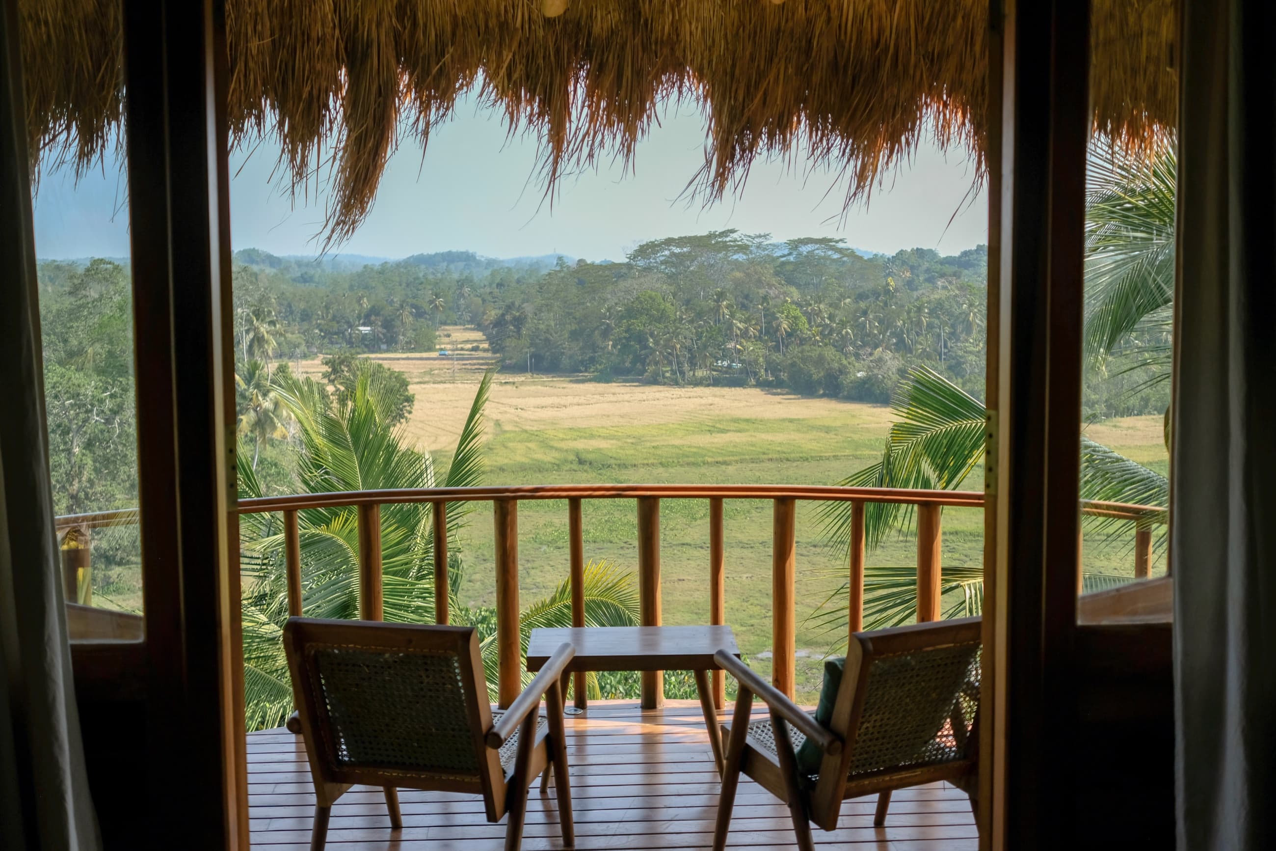 Private balcony with cane chairs overlooking rice paddies and jungle — Tekanda Lodge, Ahangama, Sri Lanka