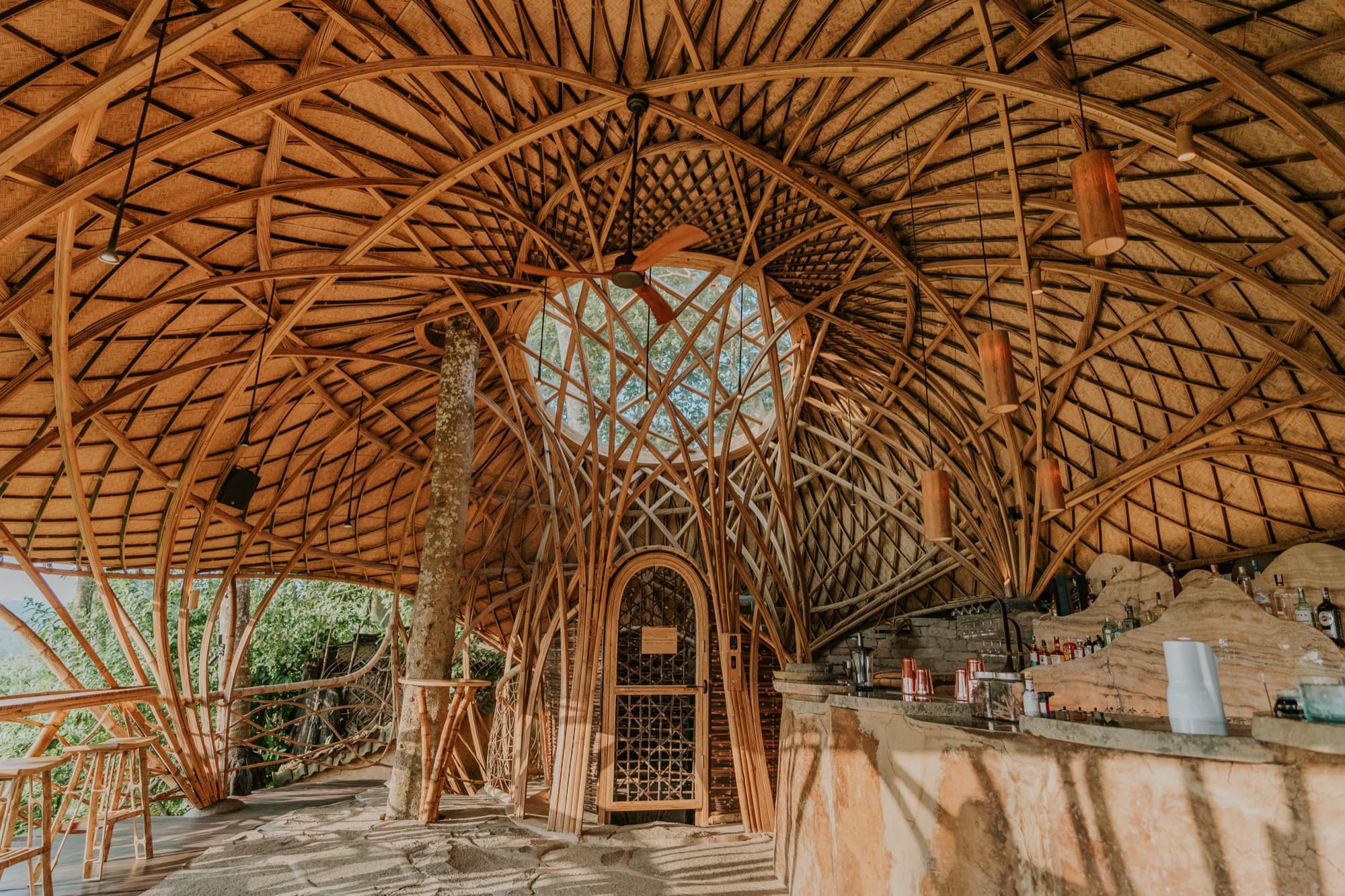 Vaulted bamboo bar interior with a woven lattice roof