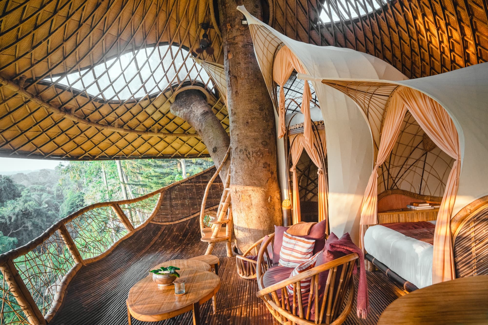 Canopy bed inside a bamboo house open to the jungle