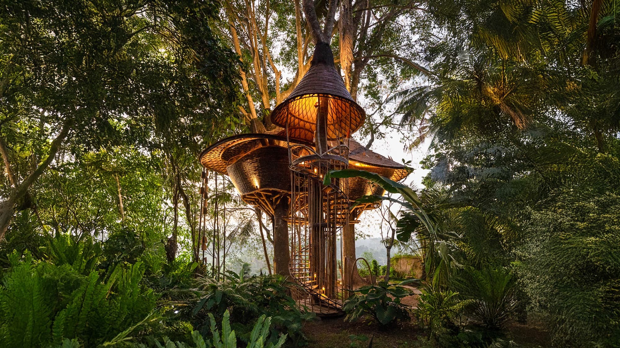 Bamboo house lit at dusk among the trees