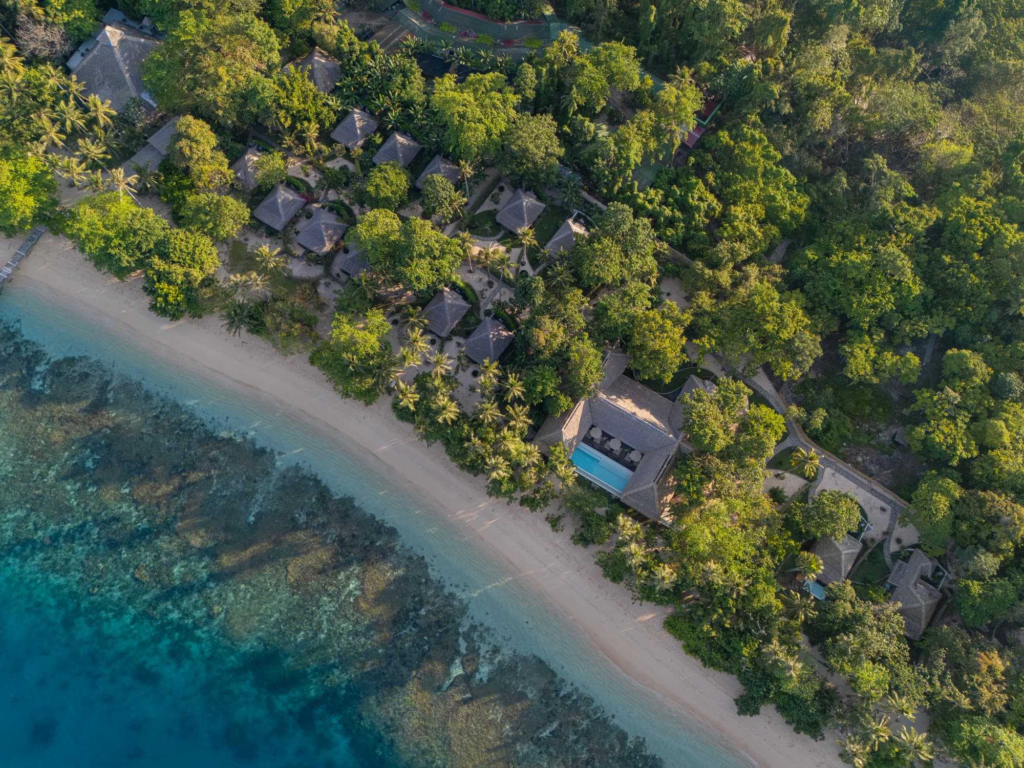 Aerial view of Coral Eye and its beach on Bangka Island at sunset