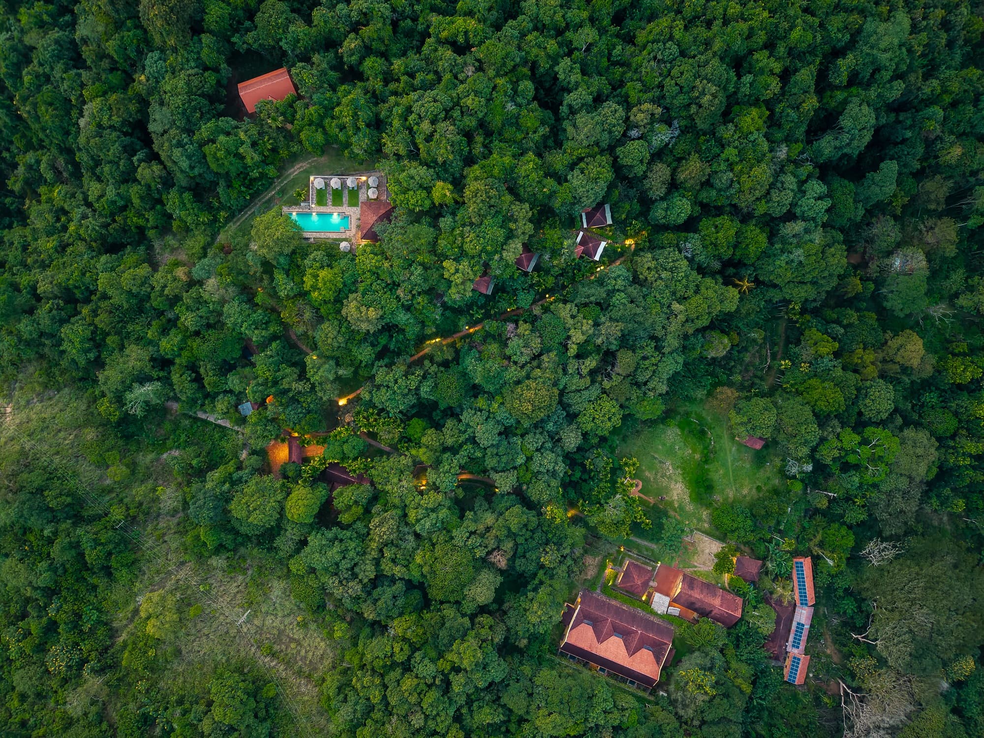 Aerial view of the pool and estate buildings set in the forest