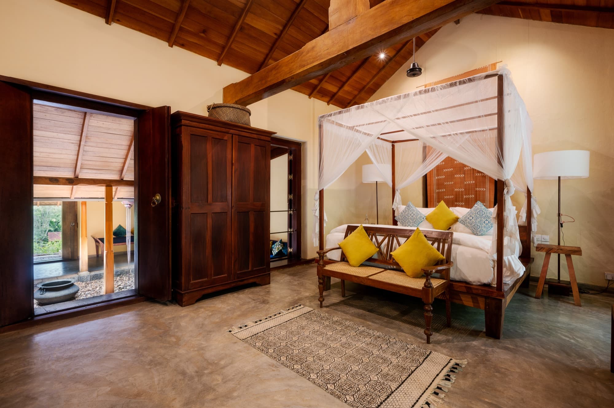 Villa Suite bedroom with a four-poster bed opening onto the garden
