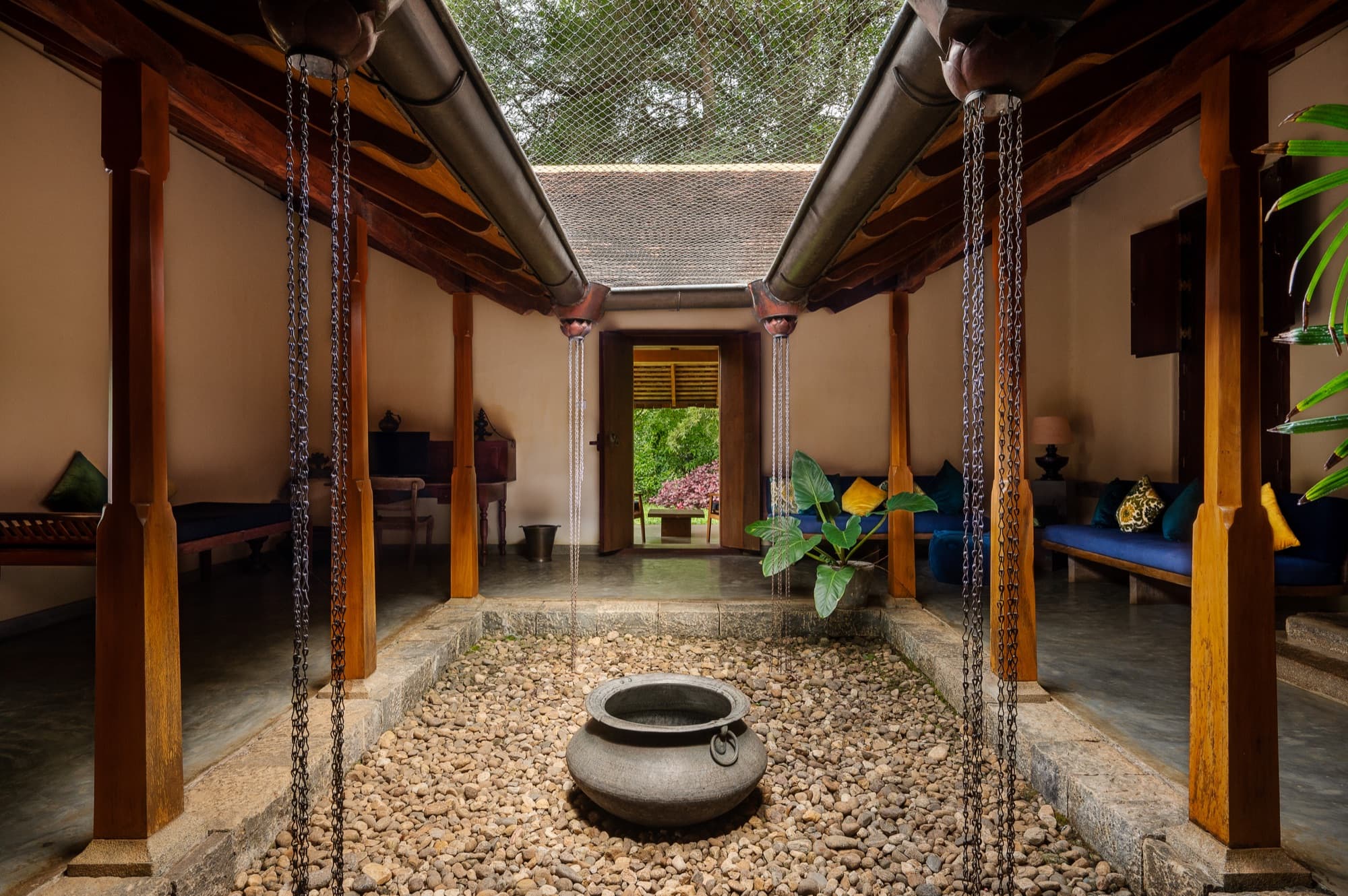 Private open-air courtyard of a Villa Suite with timber pillars and a stone water bowl