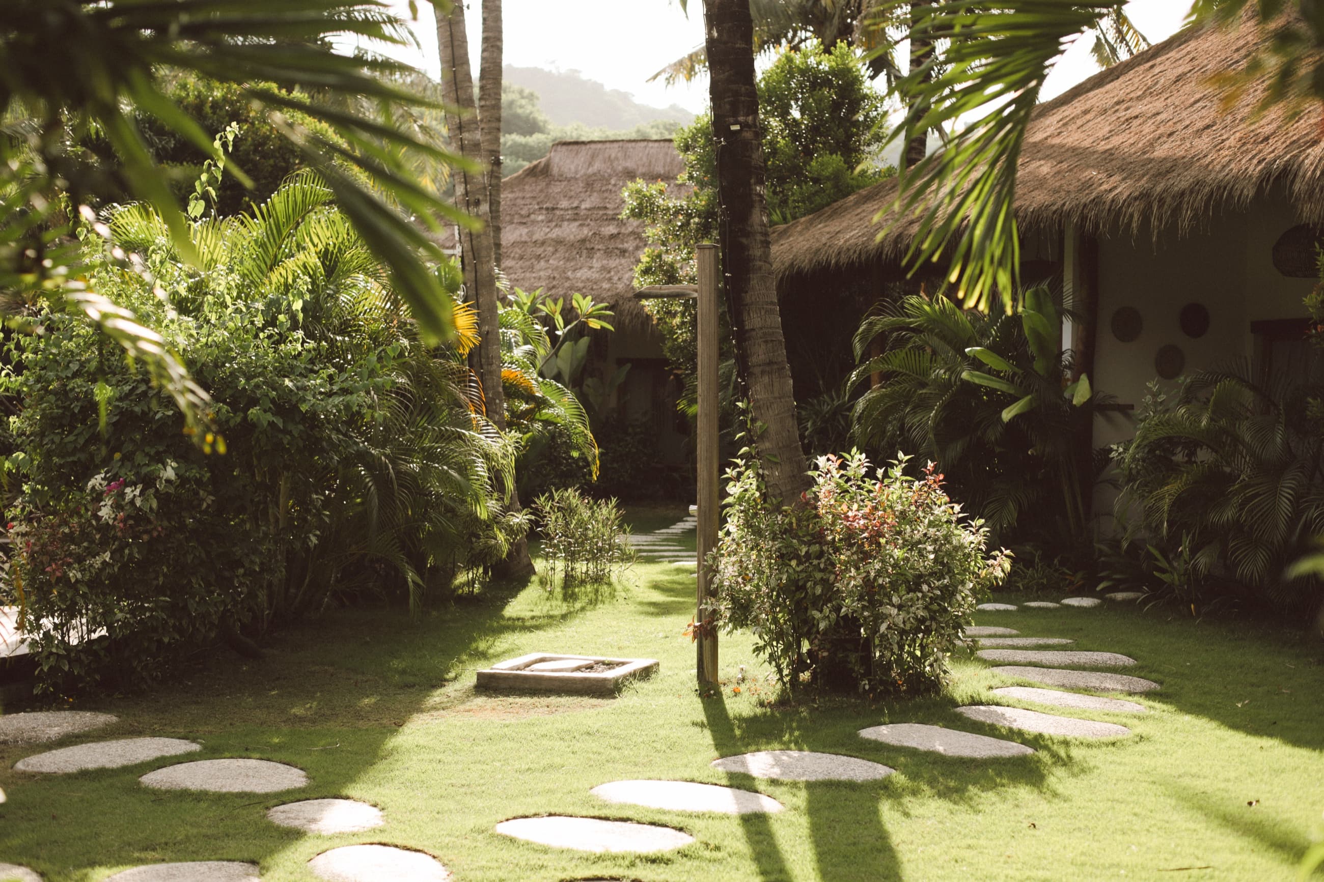 Garden of thatched-roof bungalows linked by stepping-stone paths