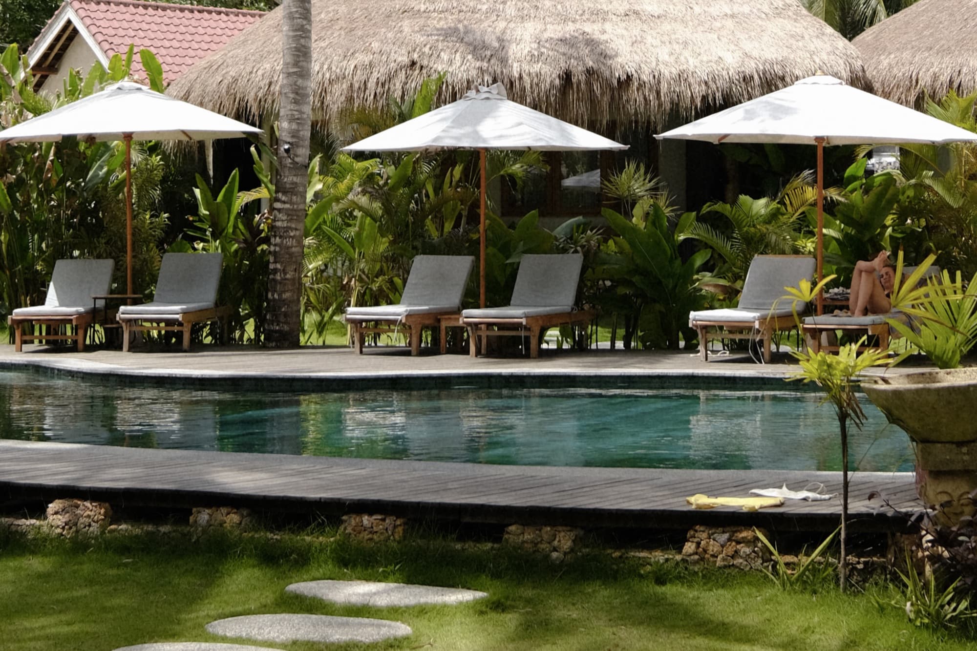 Swimming pool with sun loungers and a thatched shade pavilion