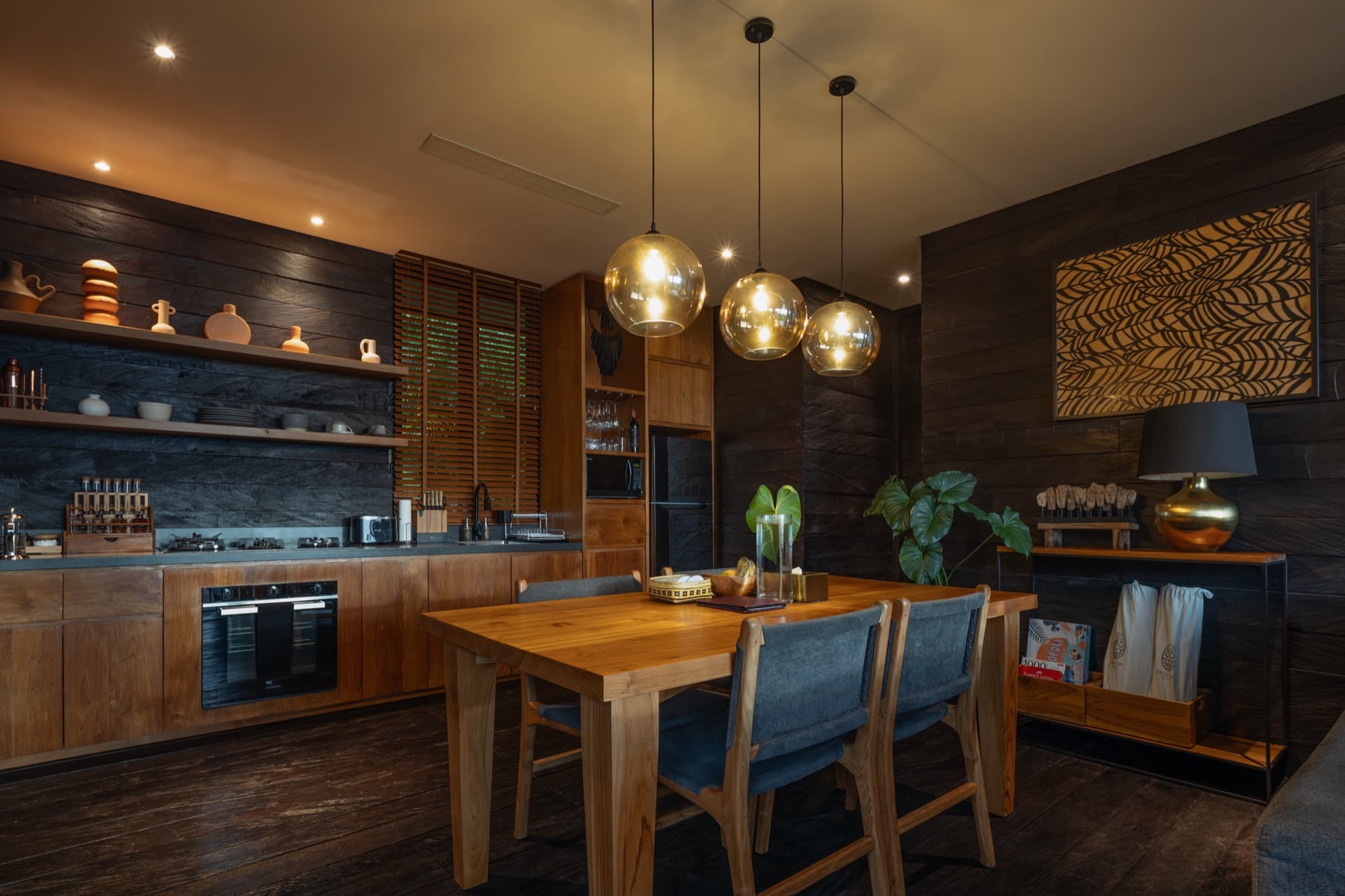 Cabin kitchen and dining area in dark timber with a full kitchen and pendant lights