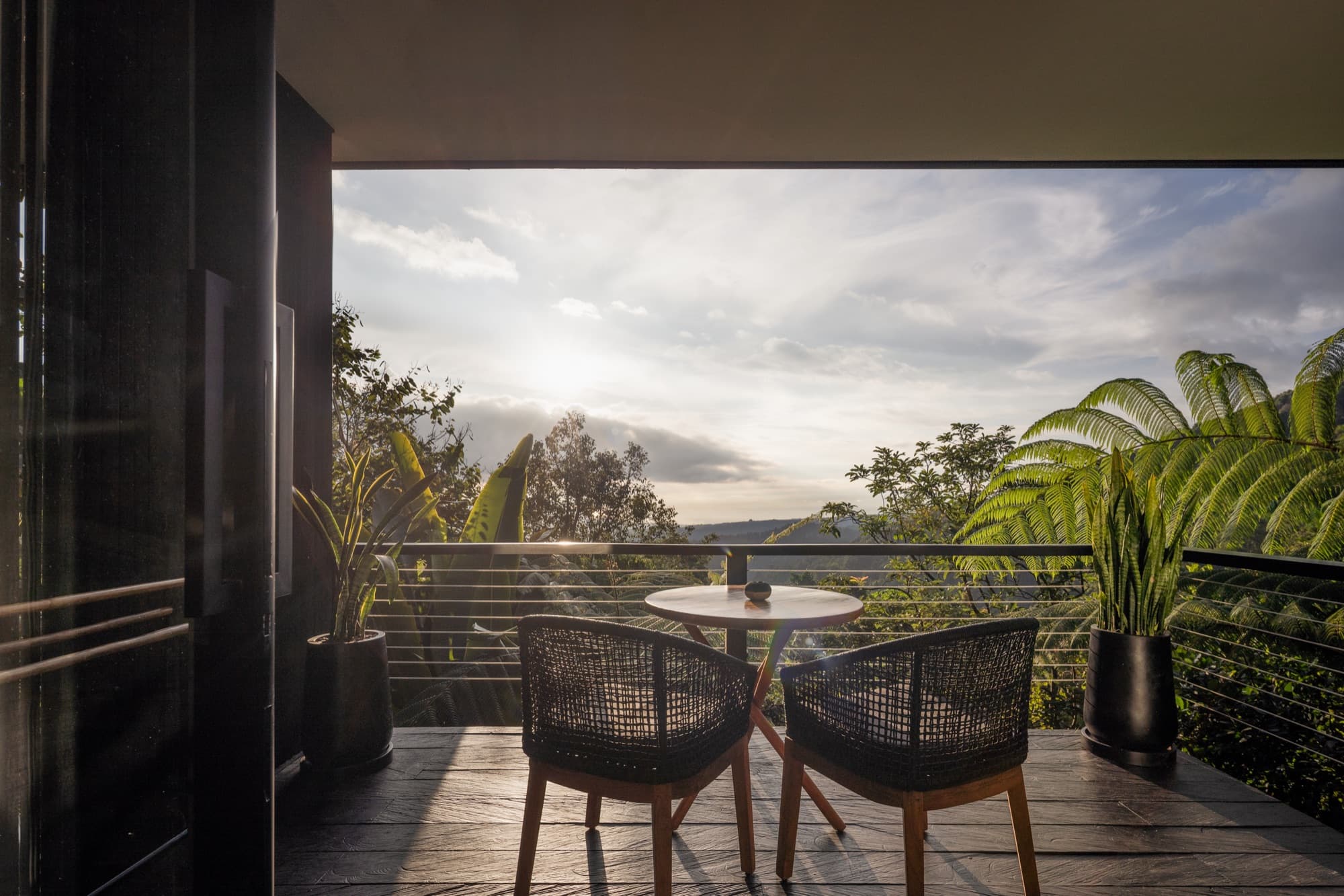 Cabin balcony table for two looking out over the misty hills of North Bali at sunset