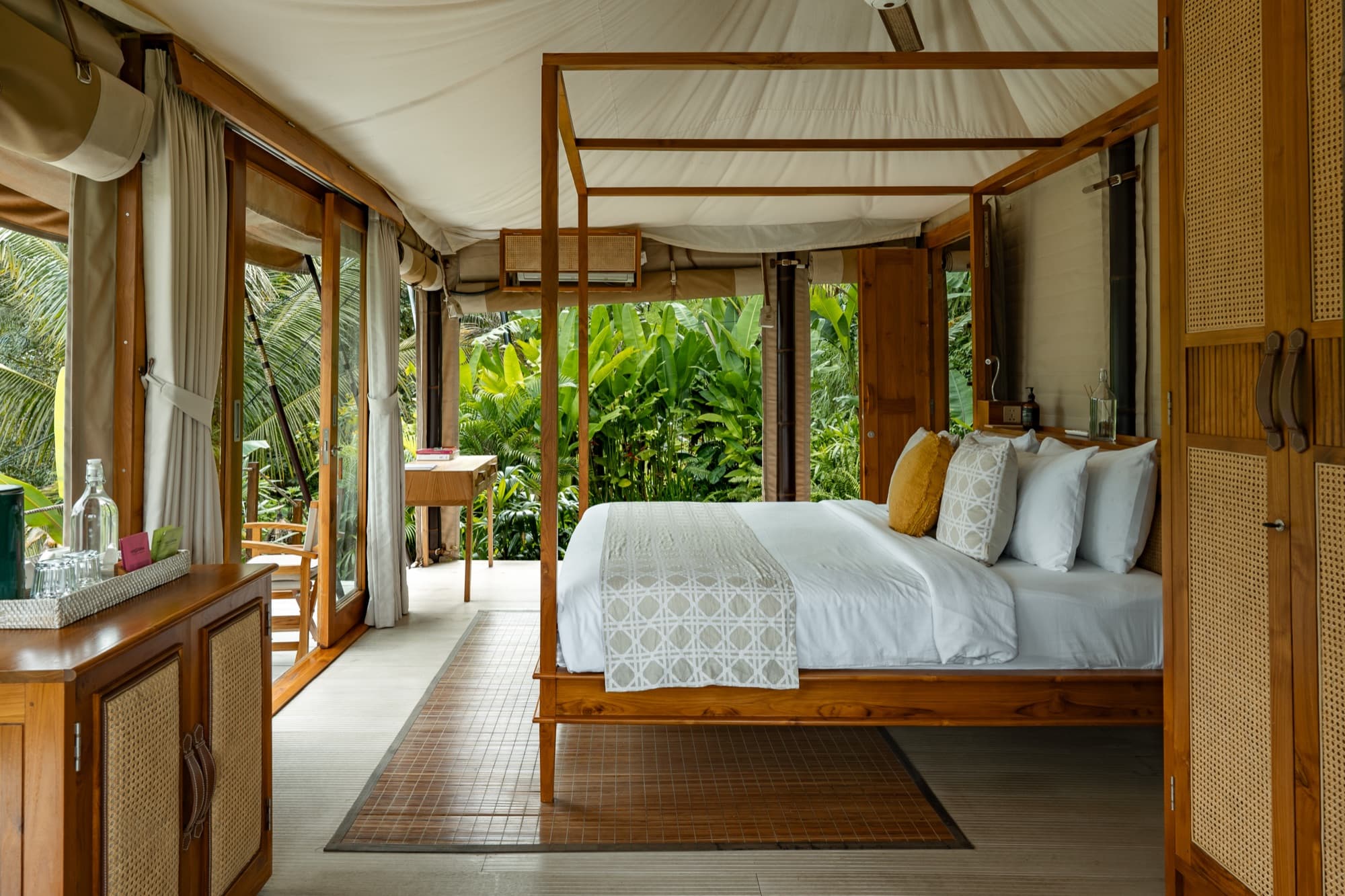 Breeze Tent king bed with rolled-up walls opening to the jungle