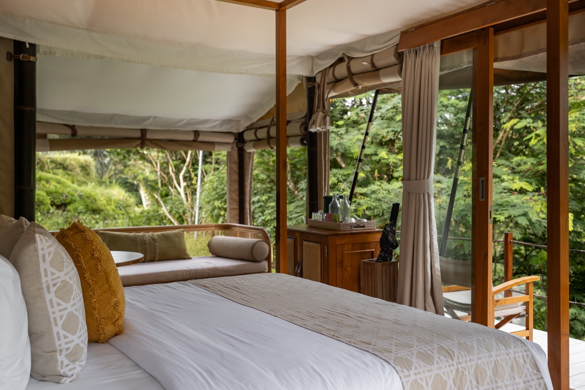 Daybed inside the Breeze Tent facing dense jungle canopy