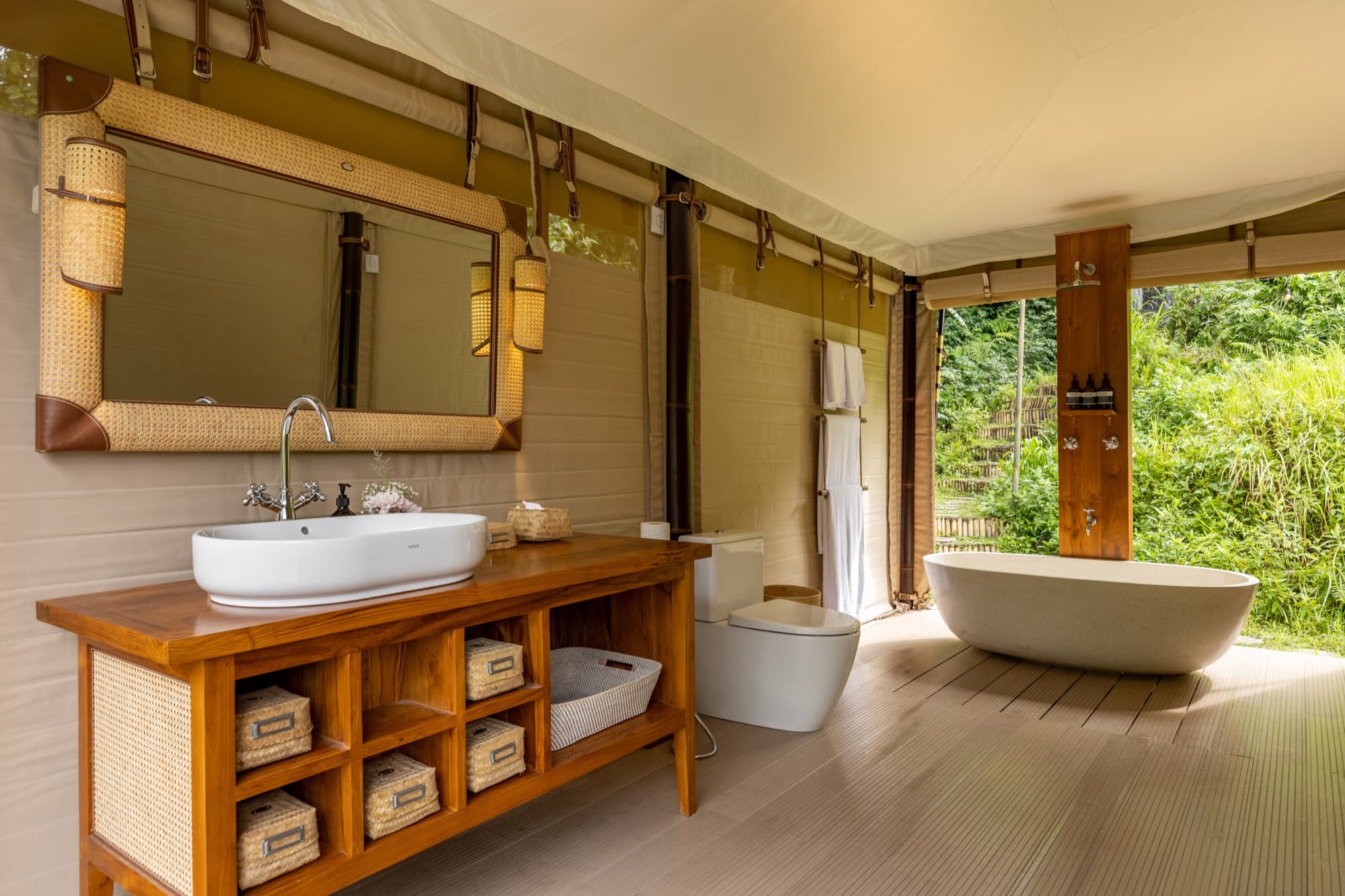 Waterfall Tent bathroom with free-standing bathtub and open-air jungle backdrop