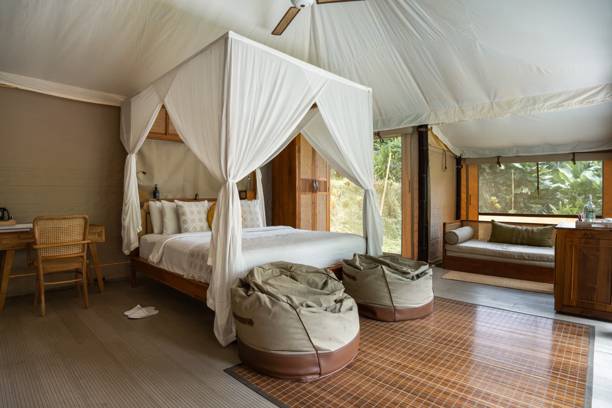 Waterfall Tent canopied king bed with bean bags and natural light