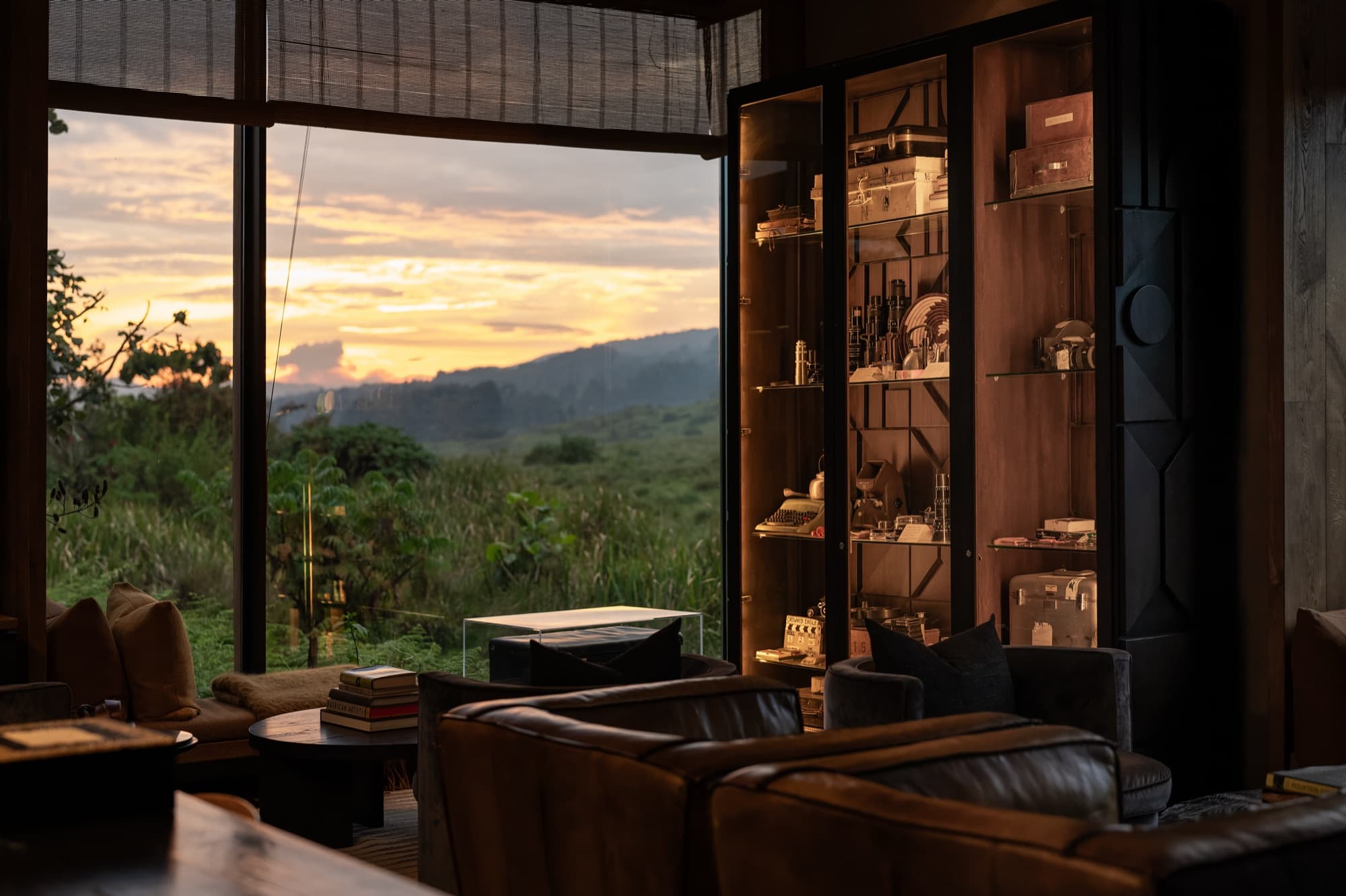 Leather sofas and display cabinets facing the valley at sunset