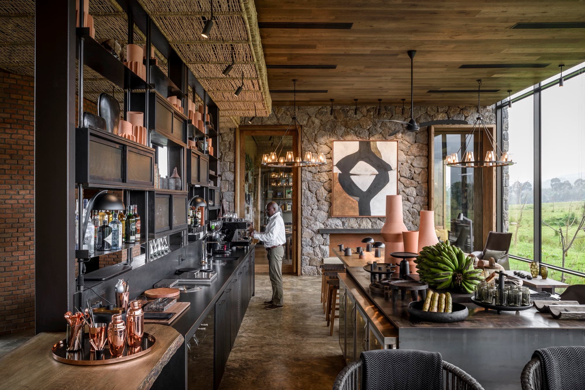 Bar with copper tableware, stone walls and windows onto the fields