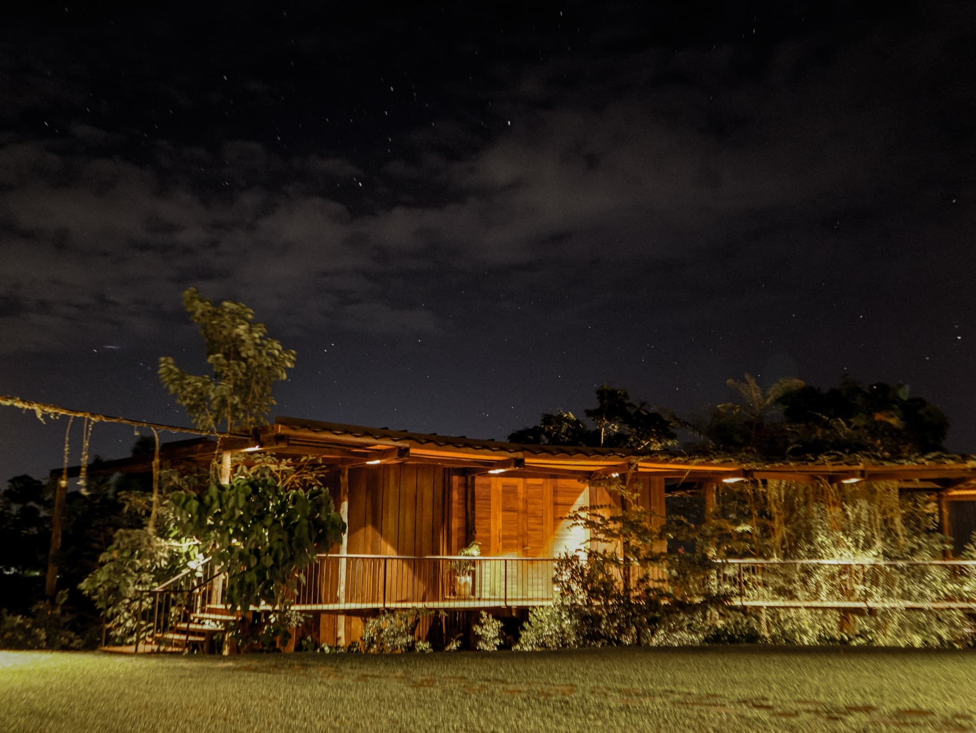 The timber roundhouse lit up under a starry night sky
