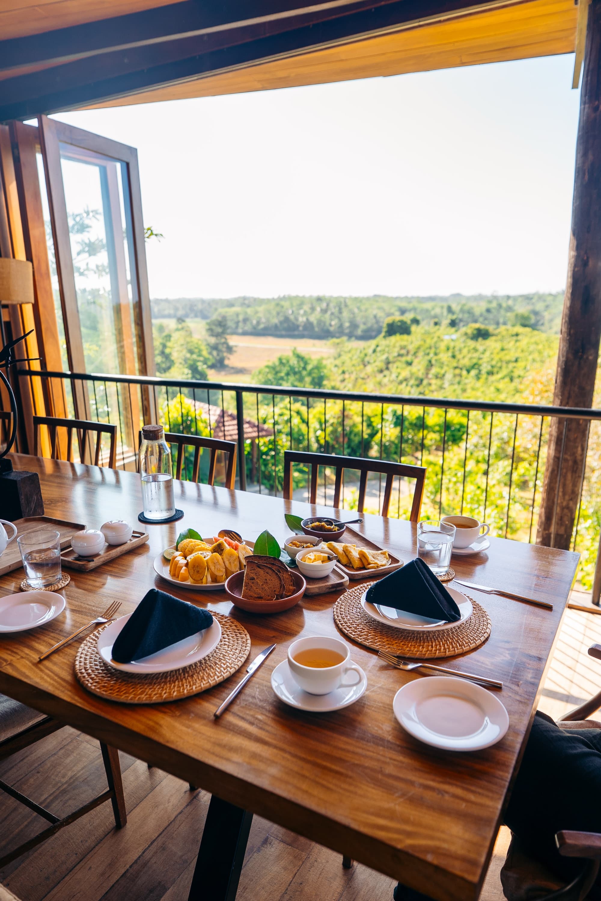 Breakfast laid on a timber table overlooking the plantation and jungle