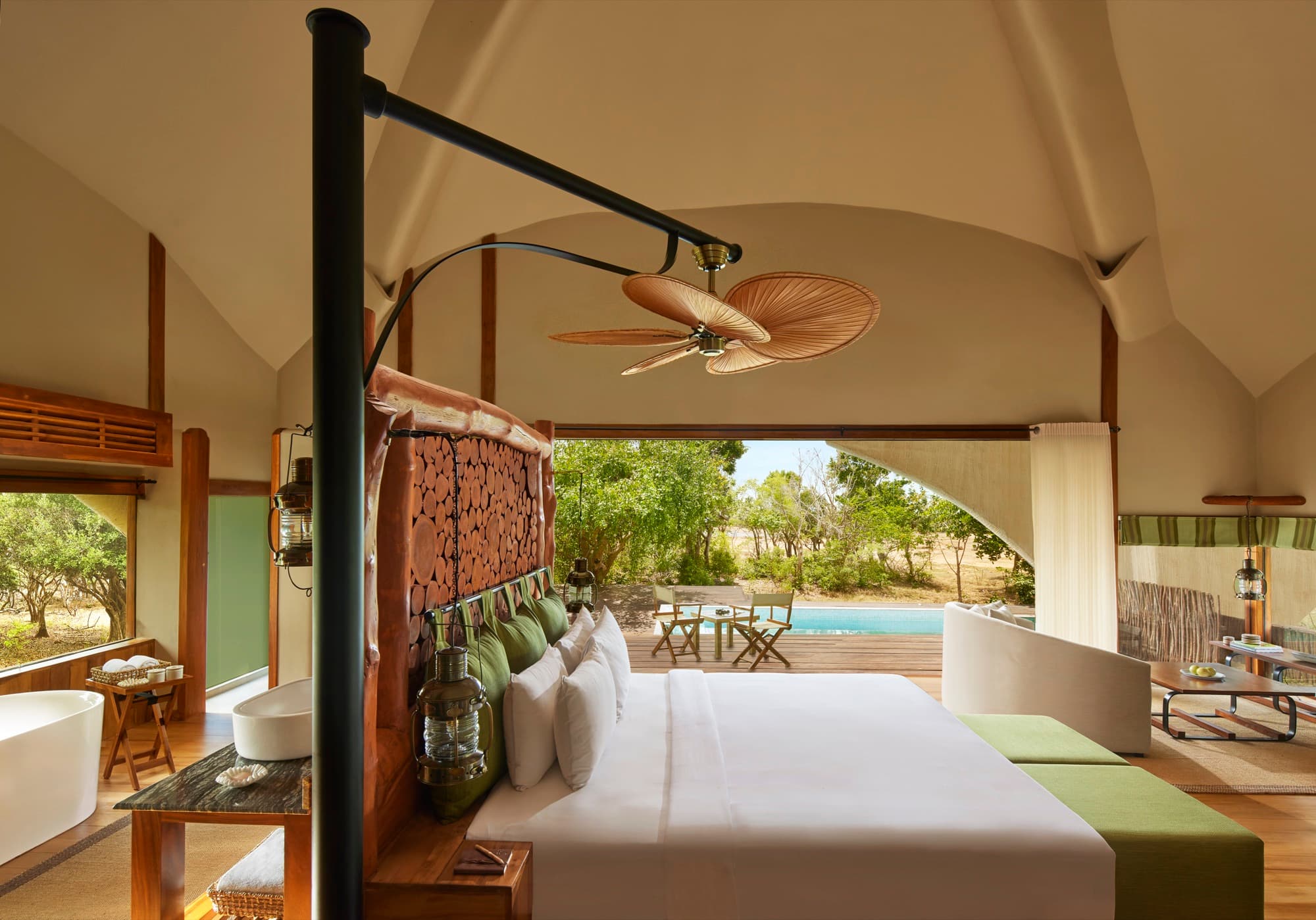 Cabin bedroom under a vaulted ceiling, opening onto the deck and its plunge pool