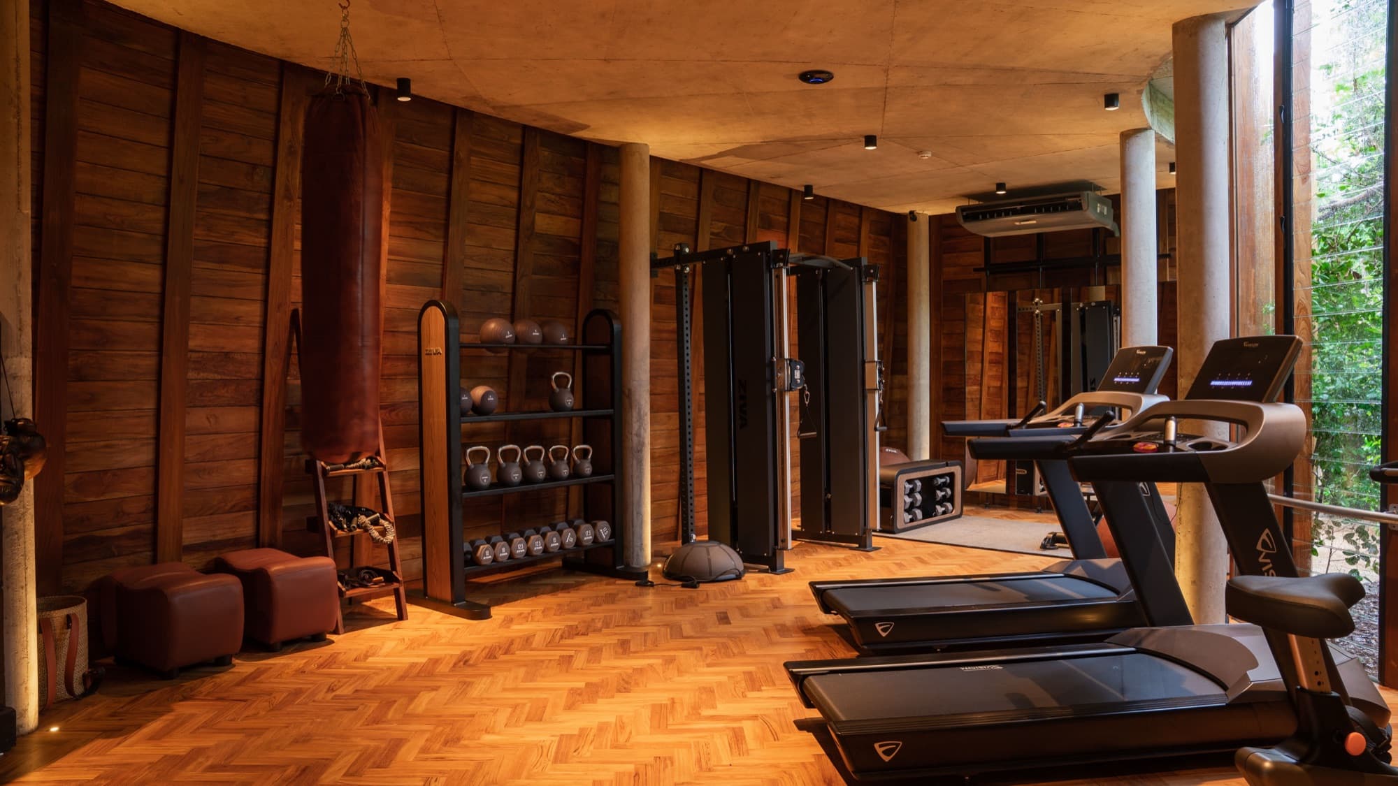 The Quarry Gym interior in teak panelling, with treadmills and free weights