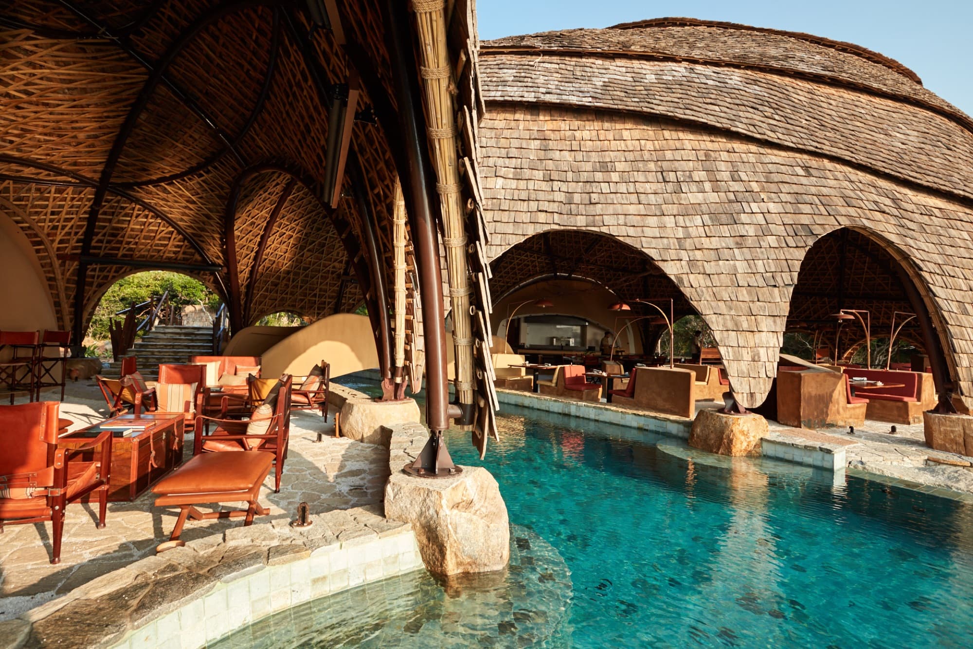 Pool and lounge of the main pavilion under a woven bamboo vault and shingle dome