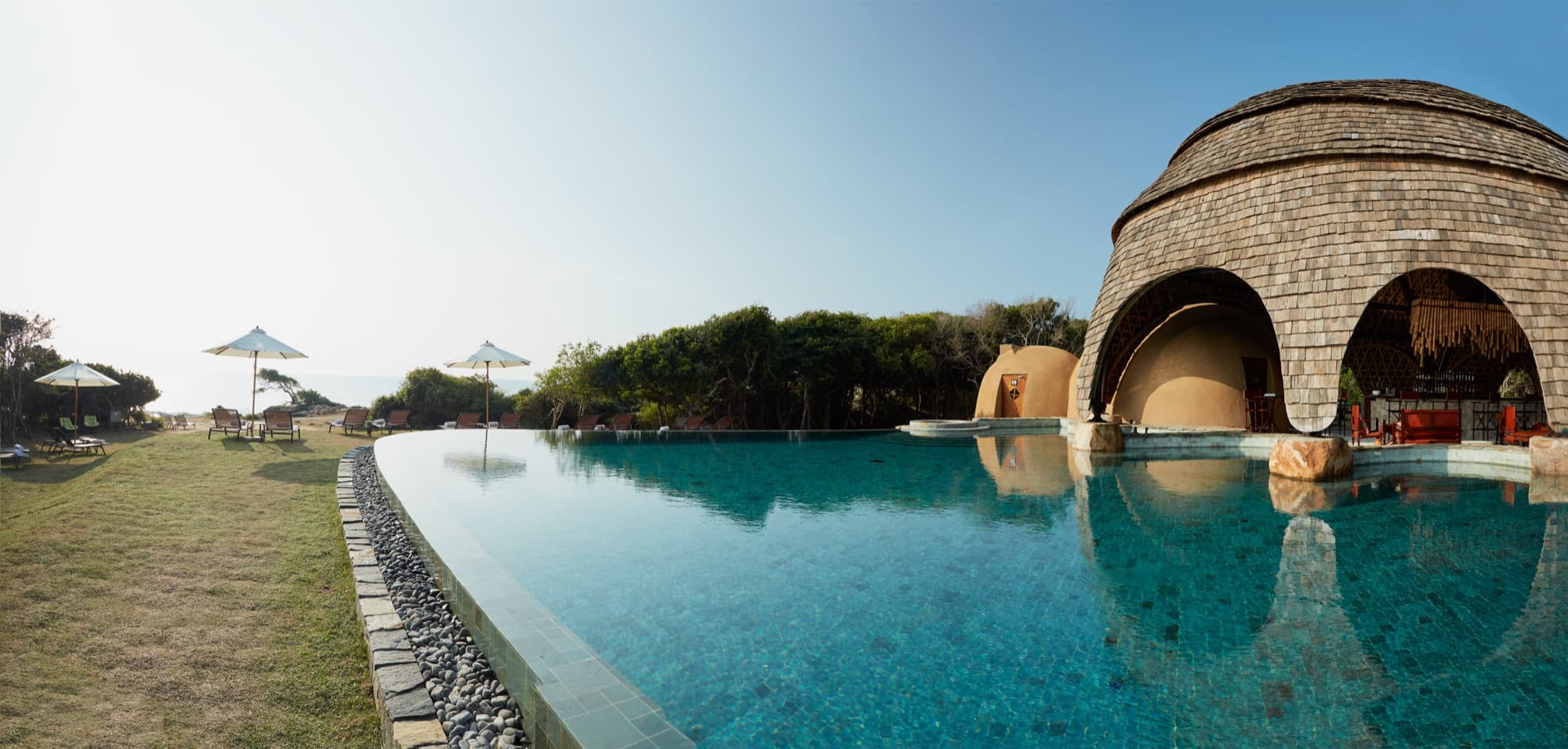 Infinity pool reaching the Indian Ocean, with the woven bamboo and shingle main pavilion on the right