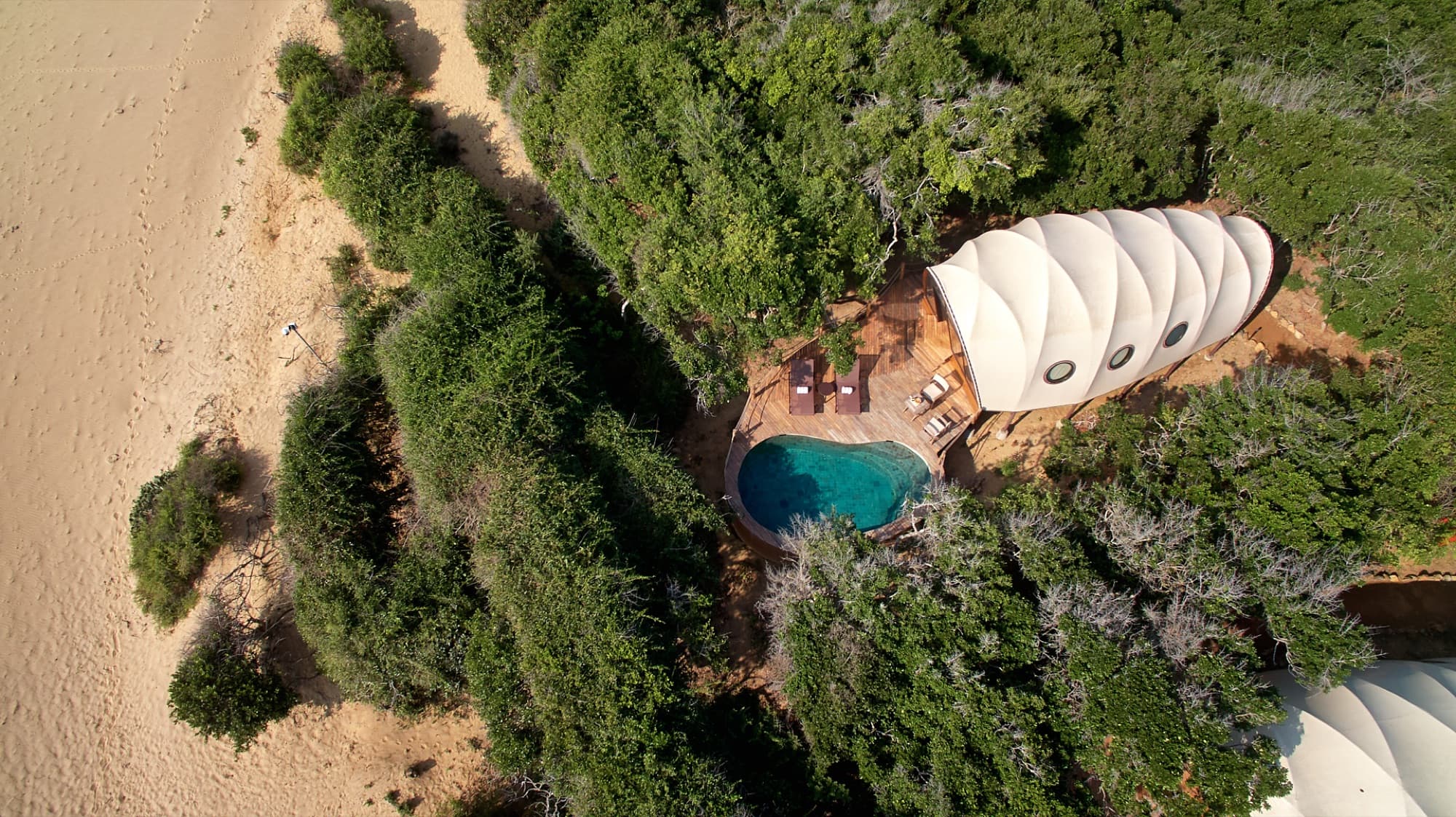Aerial top-down view of a single Cocoon tent and its private plunge pool surrounded by vegetation