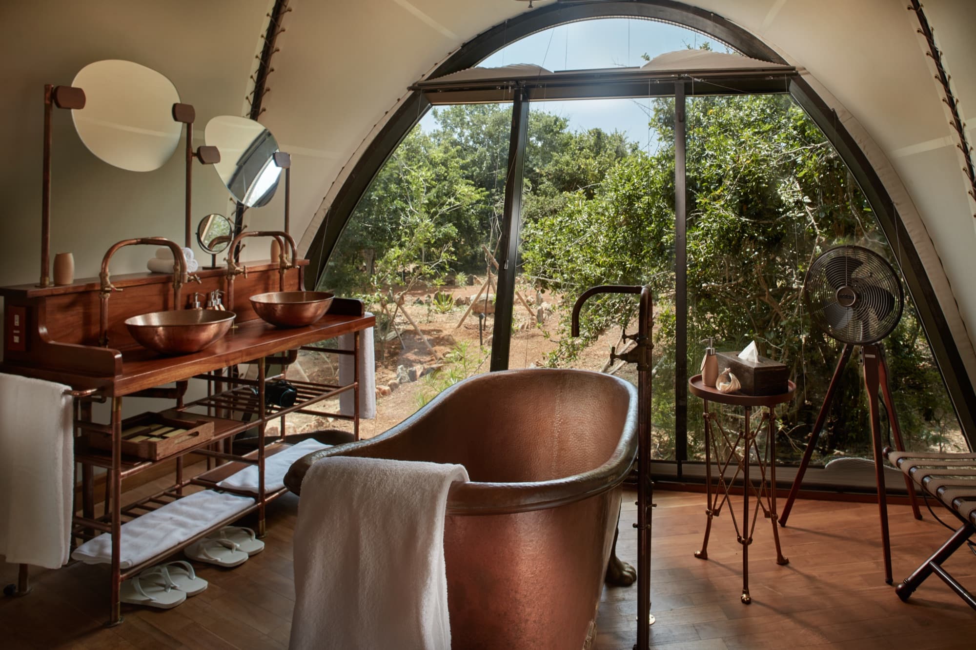 Cocoon Suite bathroom with a copper bathtub and twin copper basins, open to the jungle
