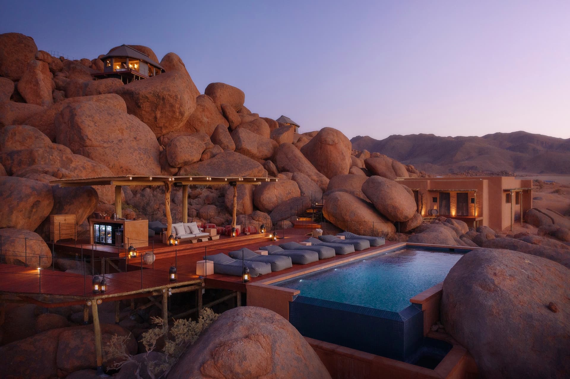 Infinity pool and terrace among the granite boulders at dusk