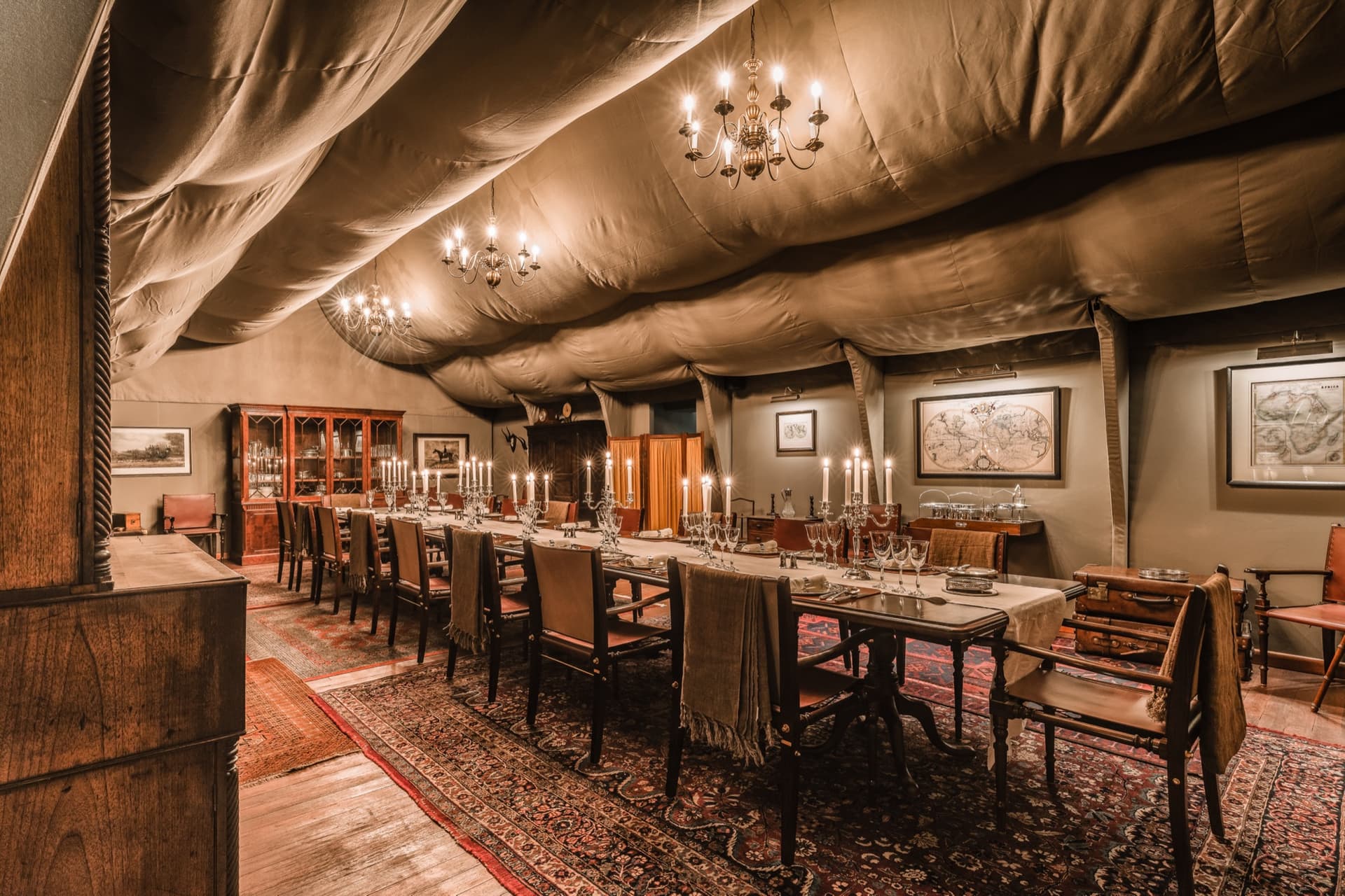 The long table of the dining tent, under candlelit chandeliers