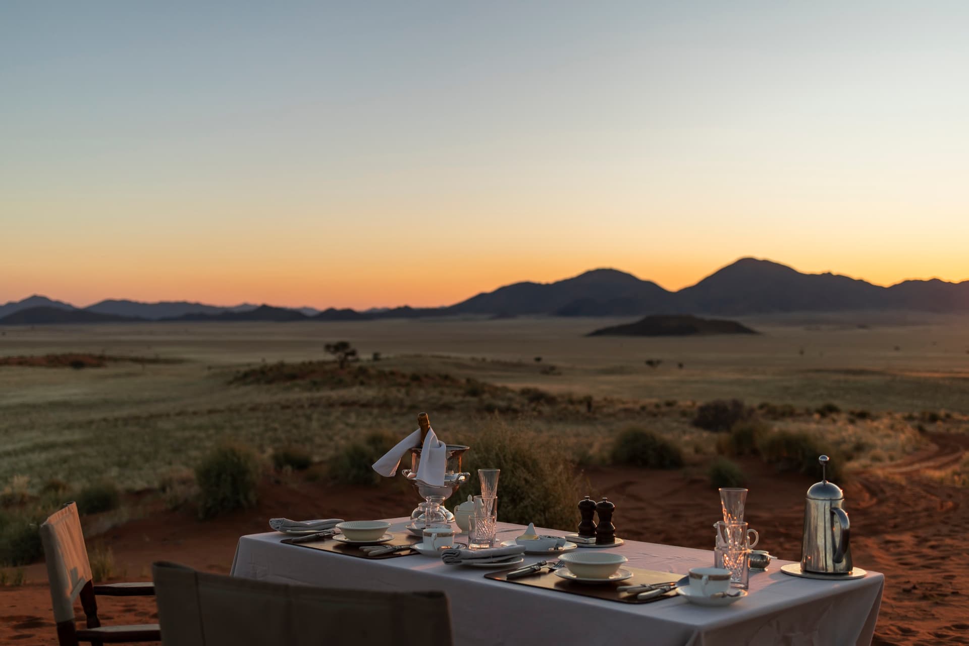 A table set in the open desert at sunset