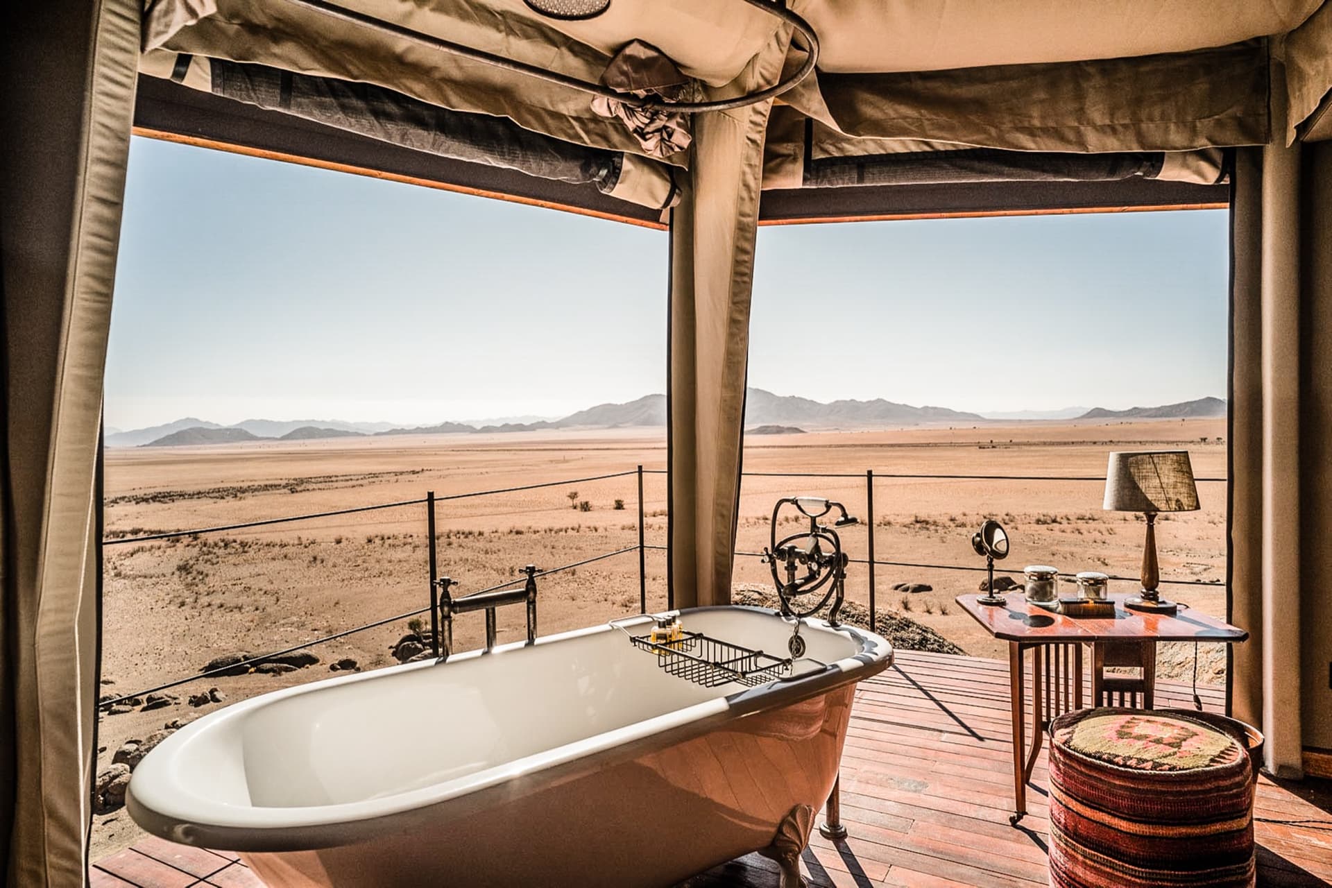 Clawfoot bathtub facing the desert through the open canvas