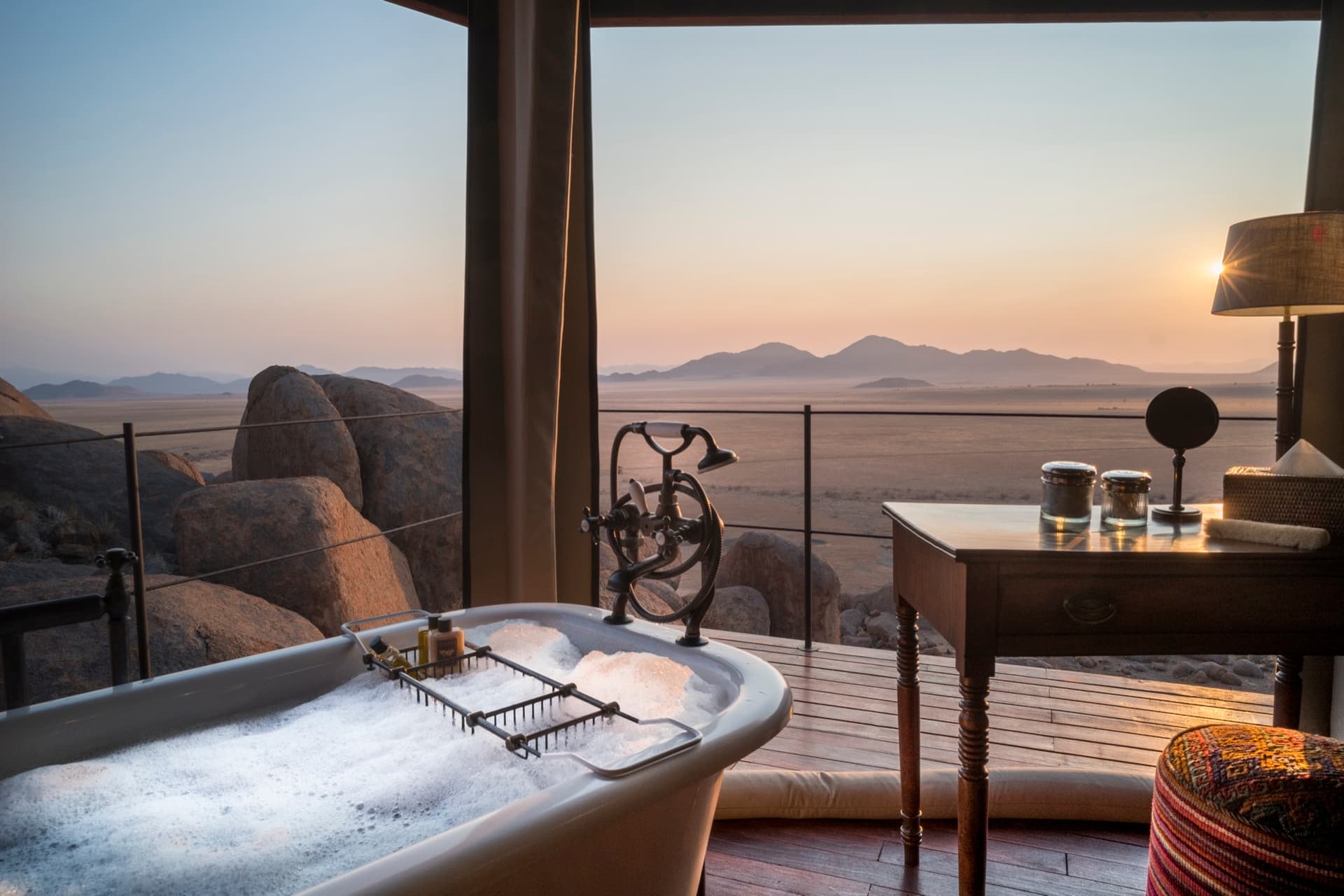 Bubble bath and desk looking out over the boulders and the desert