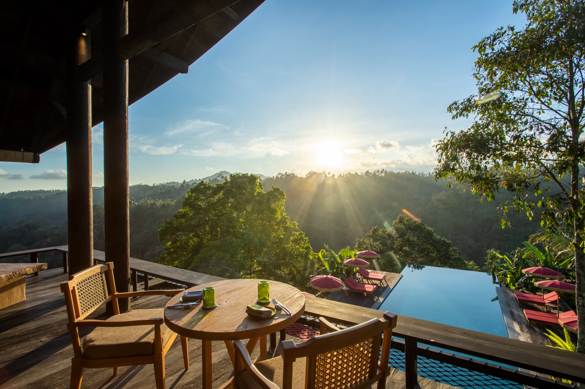 The Botanist Bar terrace at sunset, overlooking the infinity pool and jungle