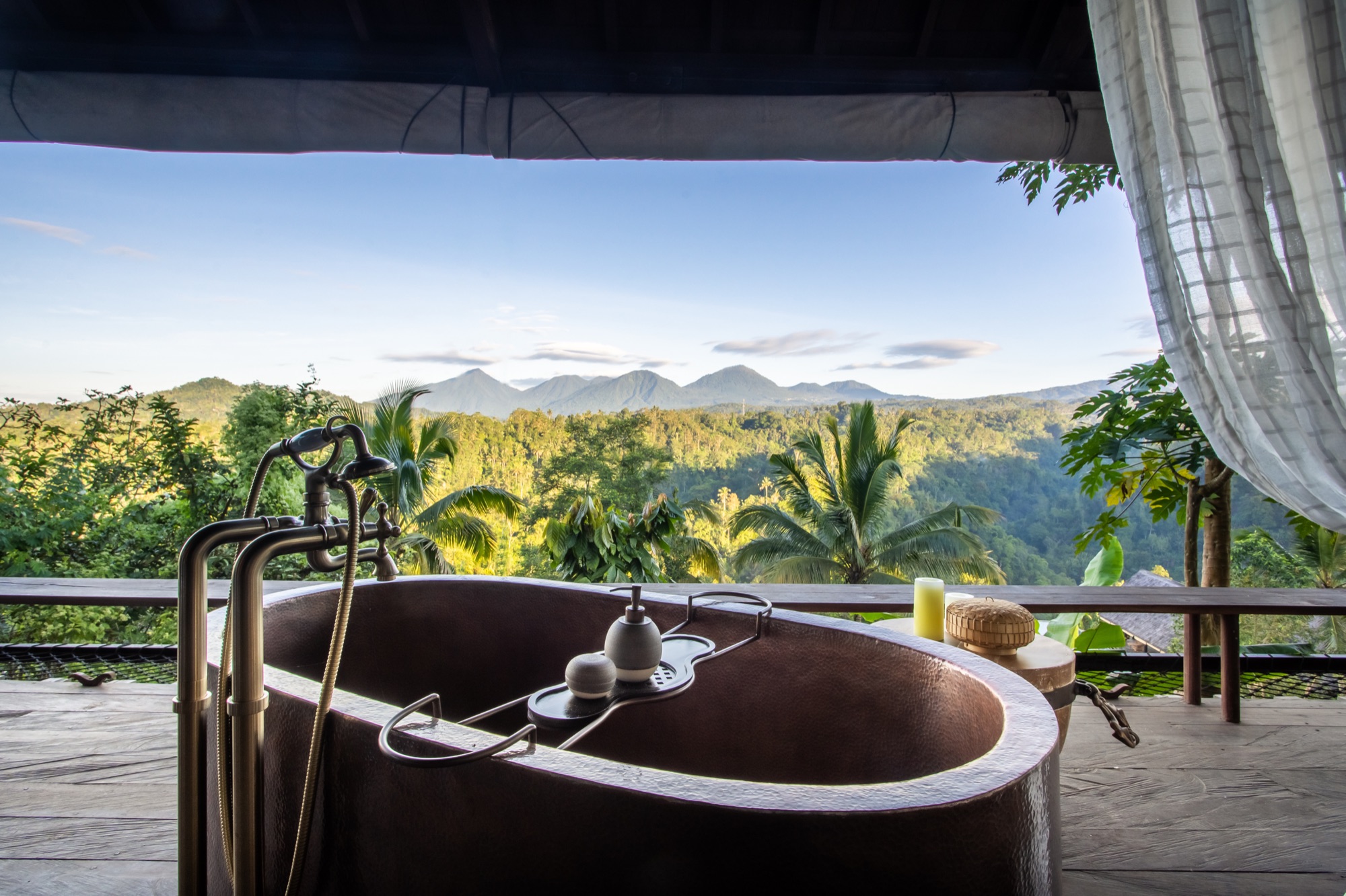 Hand-forged copper bathtub open to the jungle, with mountain views