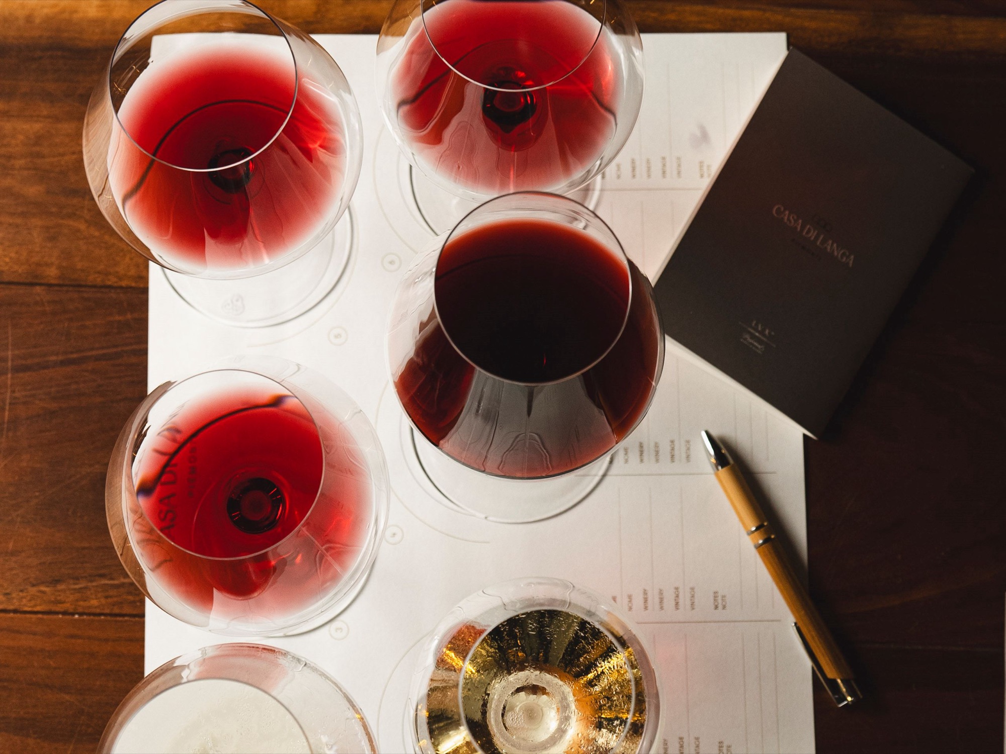 Glasses of red and white wine on a tasting sheet, seen from above