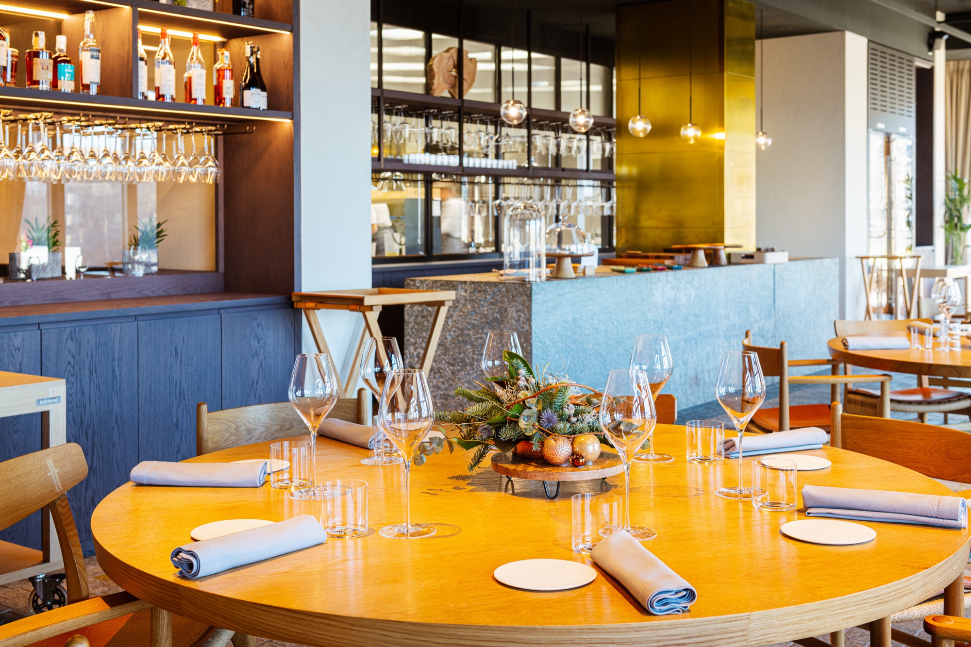 Round table set for dinner at Fàula, next to the bar