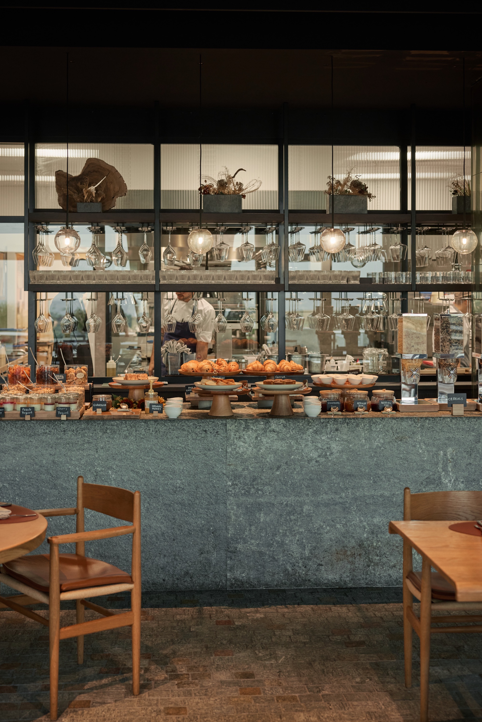 Breakfast buffet with breads and pastries behind a glass counter