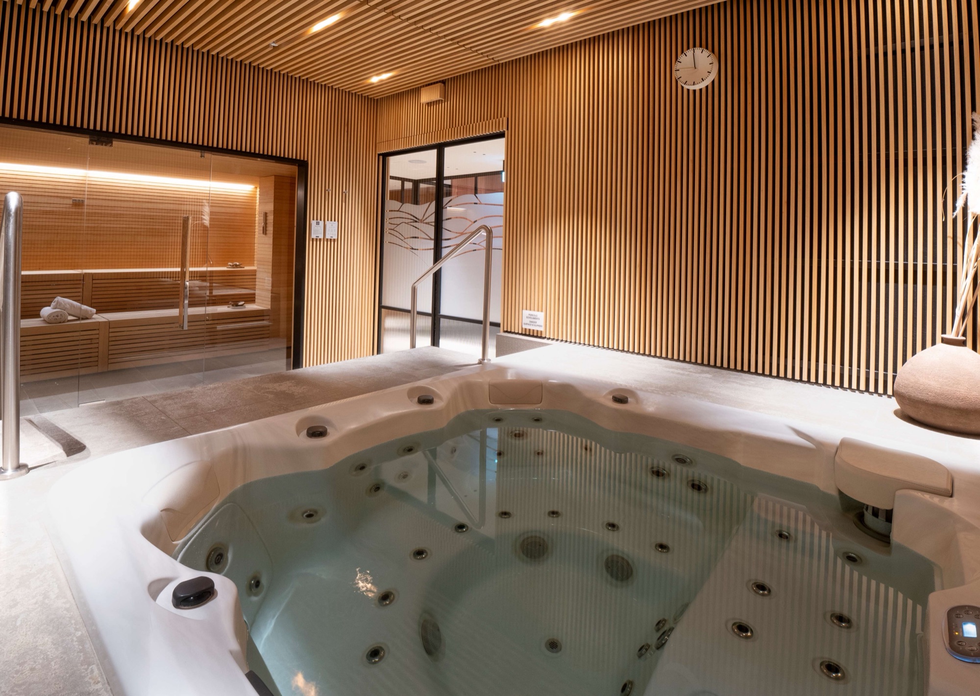 Jacuzzi in the spa's private wellness area, lined with wooden slats